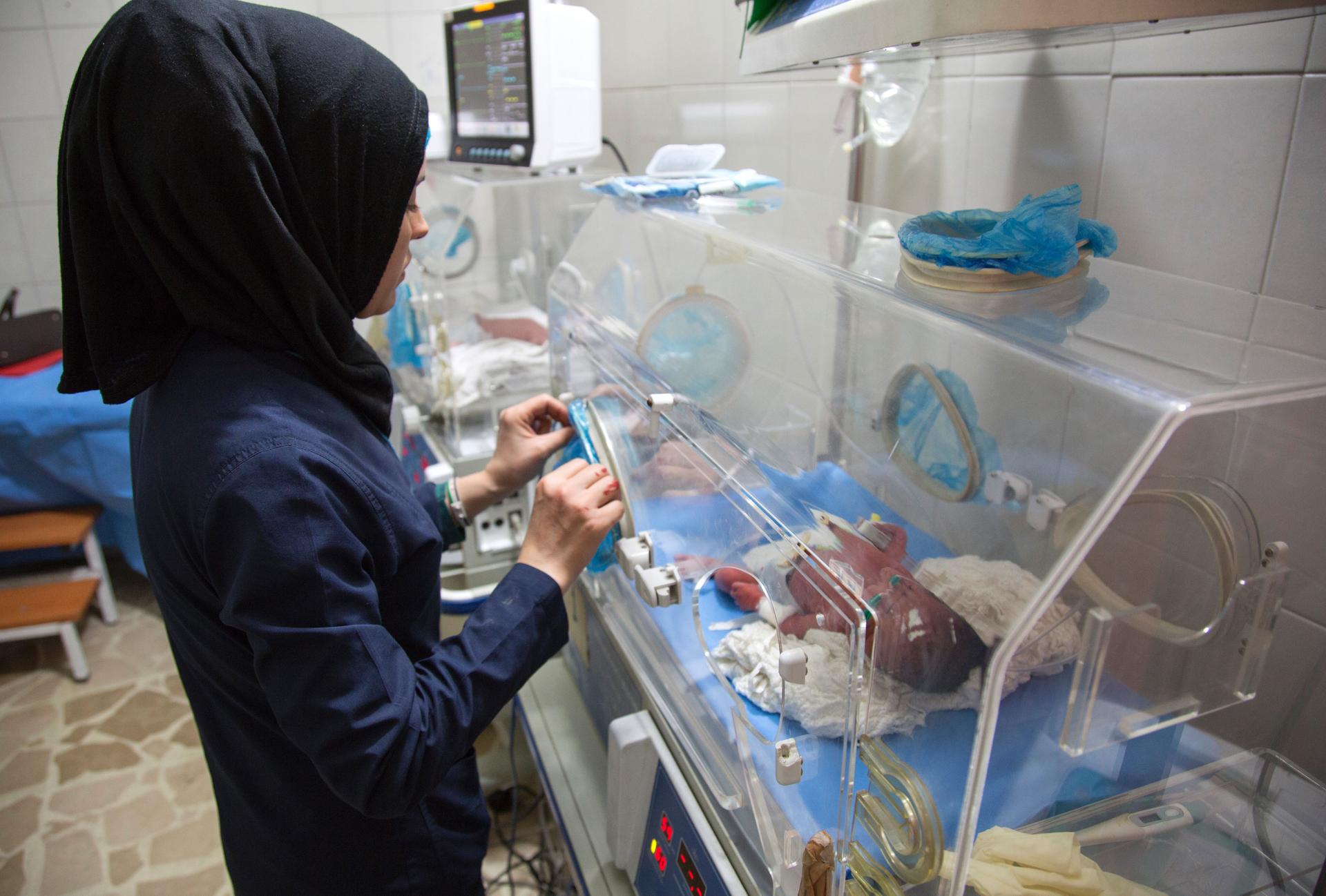 A Syrian nurse stands next to incubators with newborns who were evacuated by medical staff at a children's hospital into the basement following reported government bombardment on June 9, 2016.