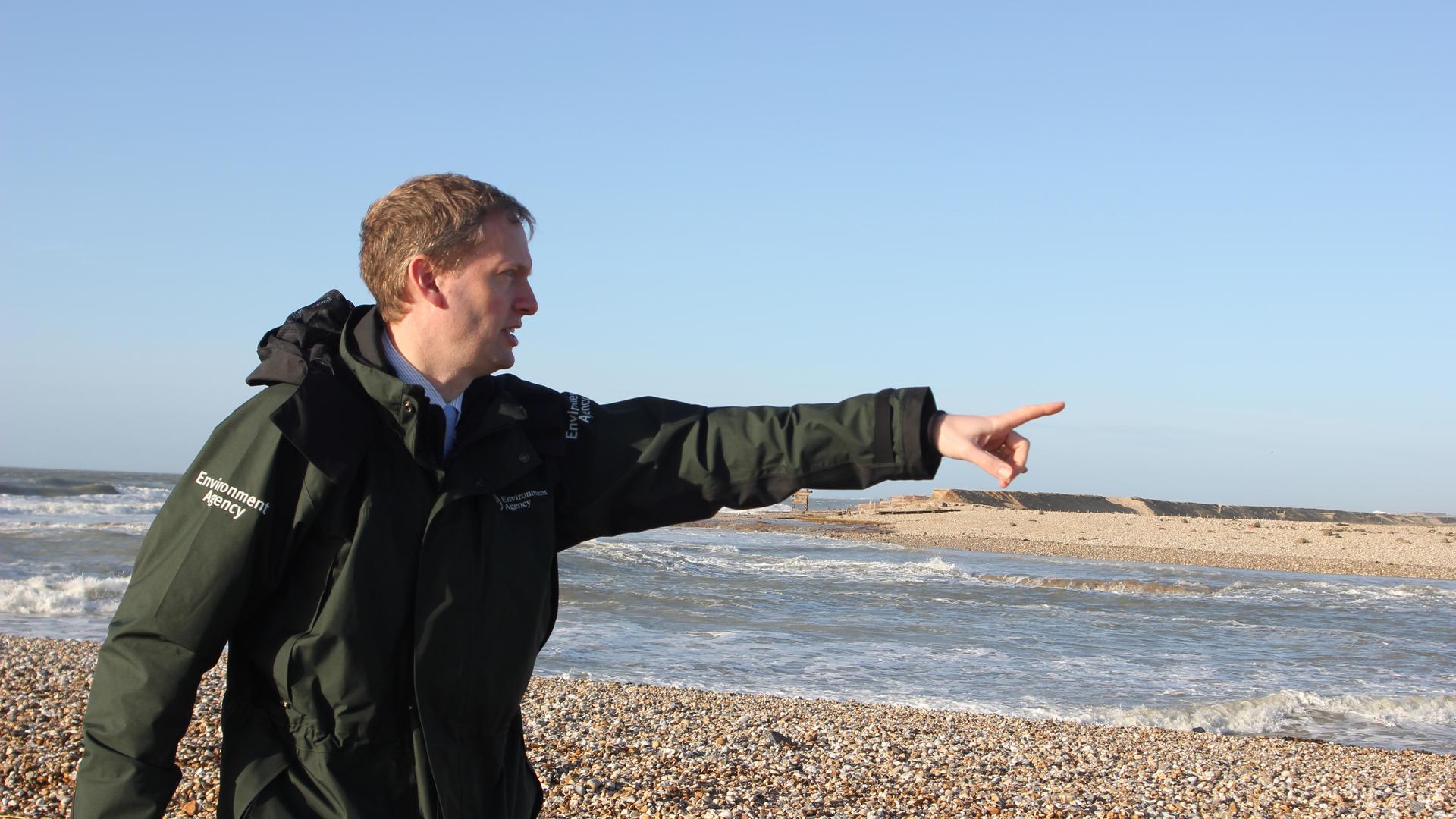 Andrew Gilham of the UKs Environment Agency points to an area of land designated to be returned to the sea