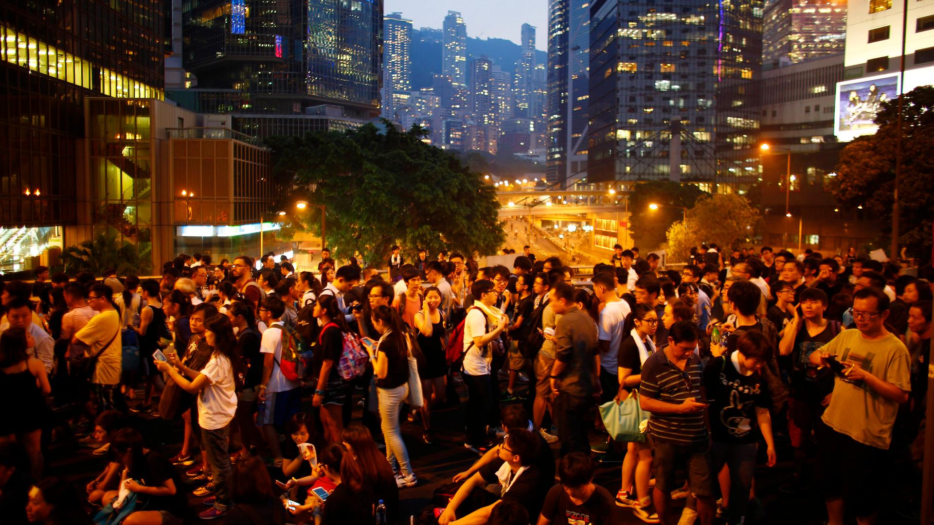 Protesters stand on a bridge as they block the main street to the financial Central district outside of the government headquarters building in Hong Kong on September 30, 2014.   