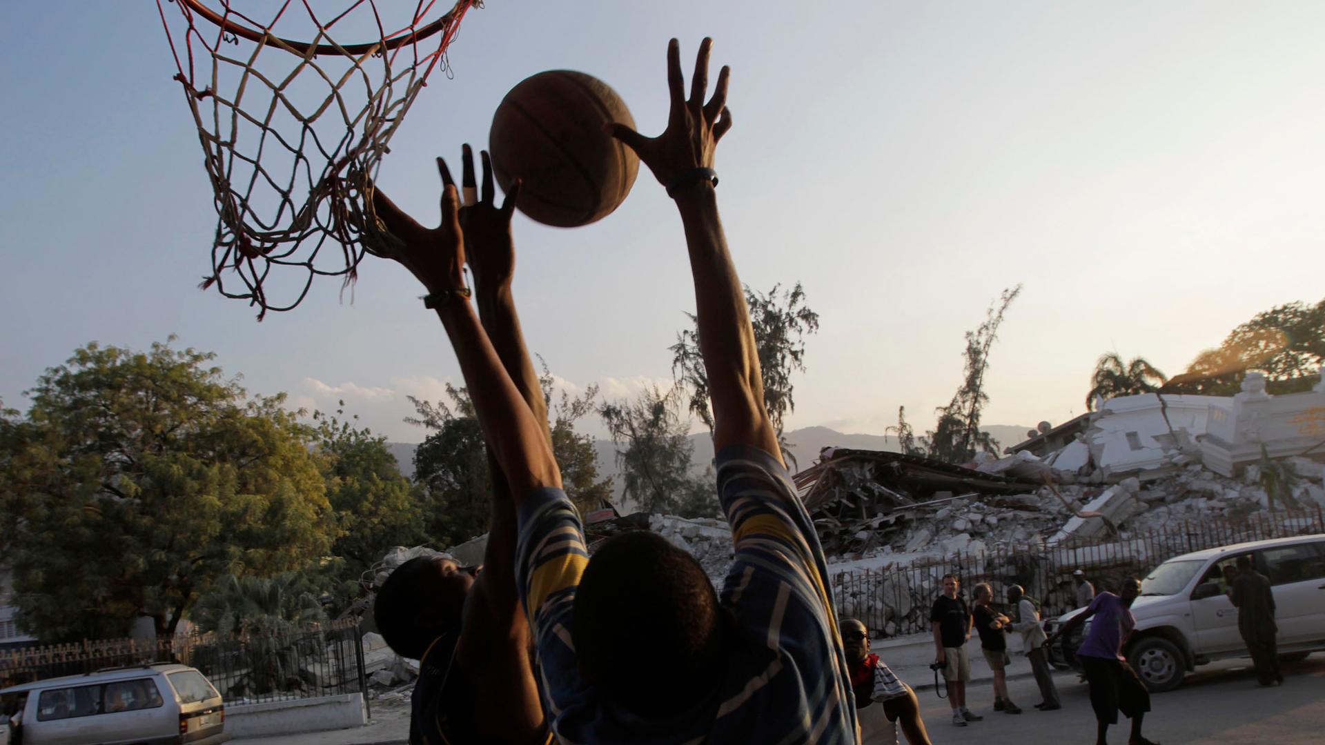 Survivors of Haiti's earthquake play basketball in front of a pile of debris of the justice palace in Port-au-Prince.