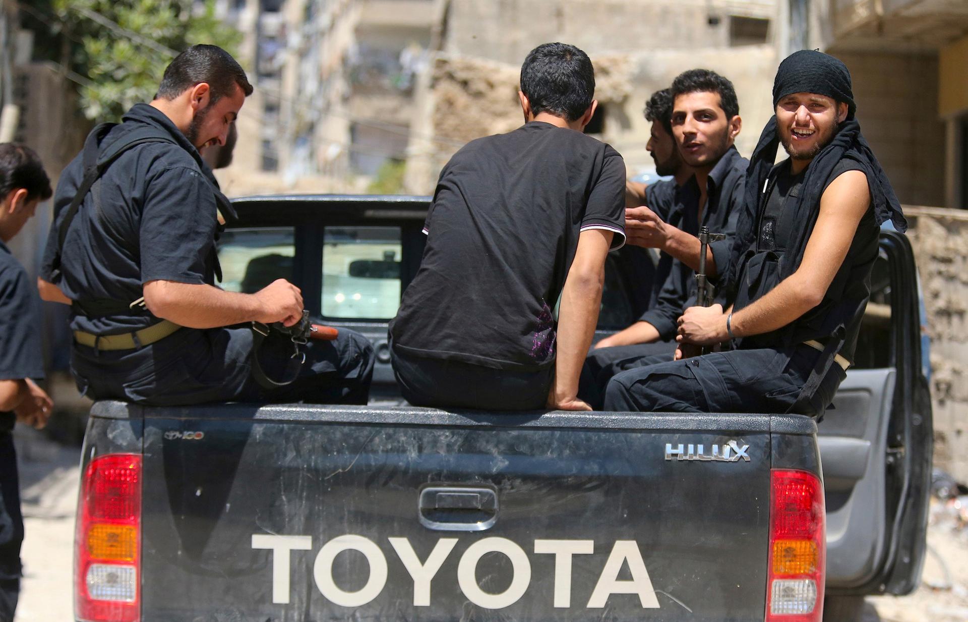 Rebels operating under the Free Syrian Army sit in a Hilux pickup truck 