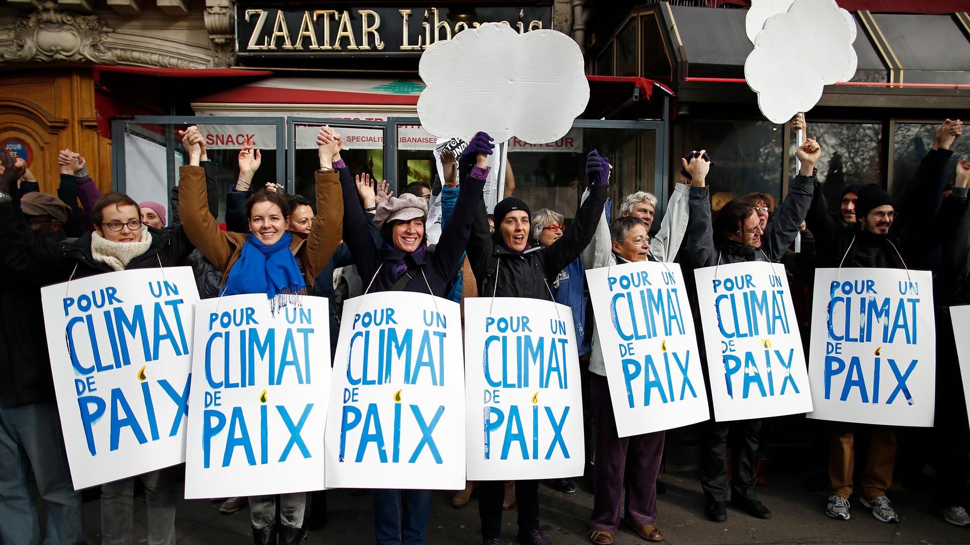Climate activists formed a 2-mile human chain Sunday along Parisian sidewalks after authorities banned a full-fledged climate march following the Nov. 13 attacks in the French capital. Demonstrators said they were determined to find ways to express their 