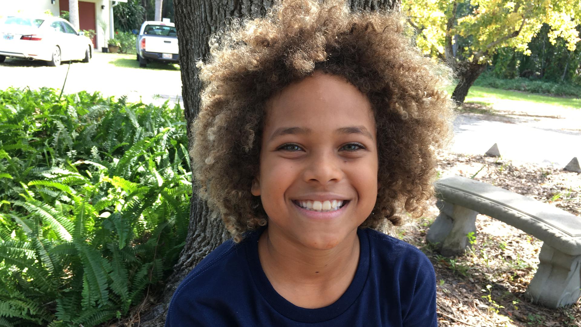 A portrait of 10-year-old Levi Draheim with brown-blonde curly hair.