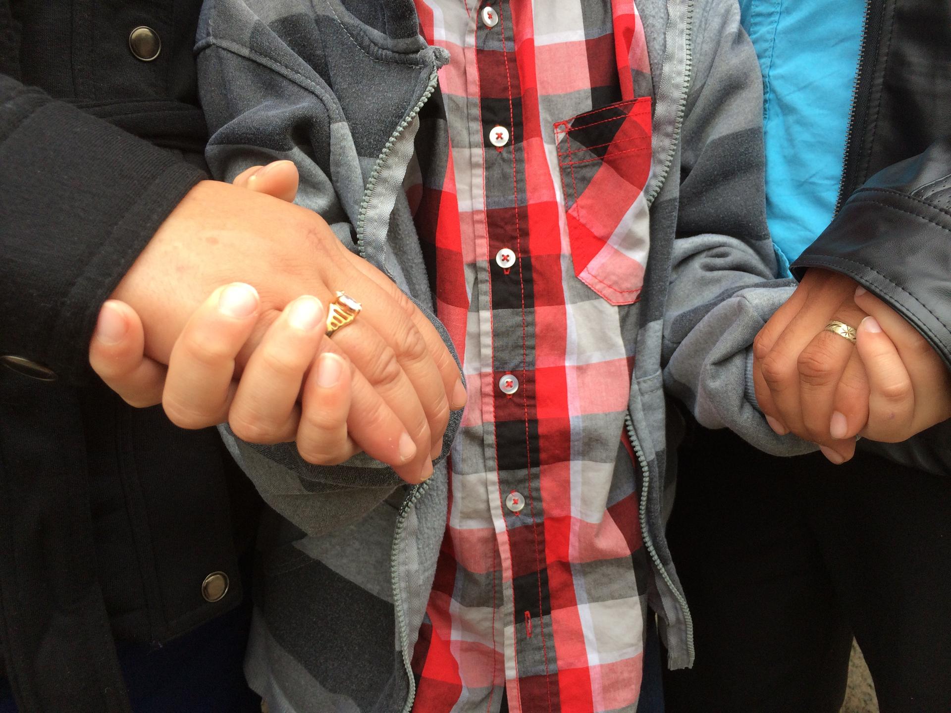 close up of three people holding hands