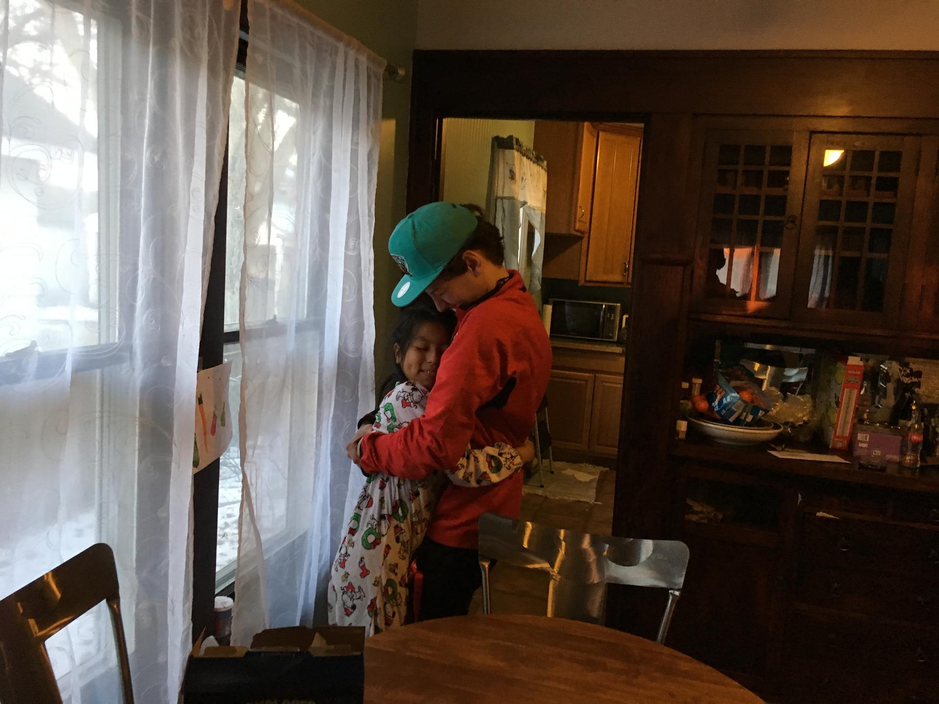 Armand Melk-Johnson, 15, hugs his host sister, Mariel, goodbye.