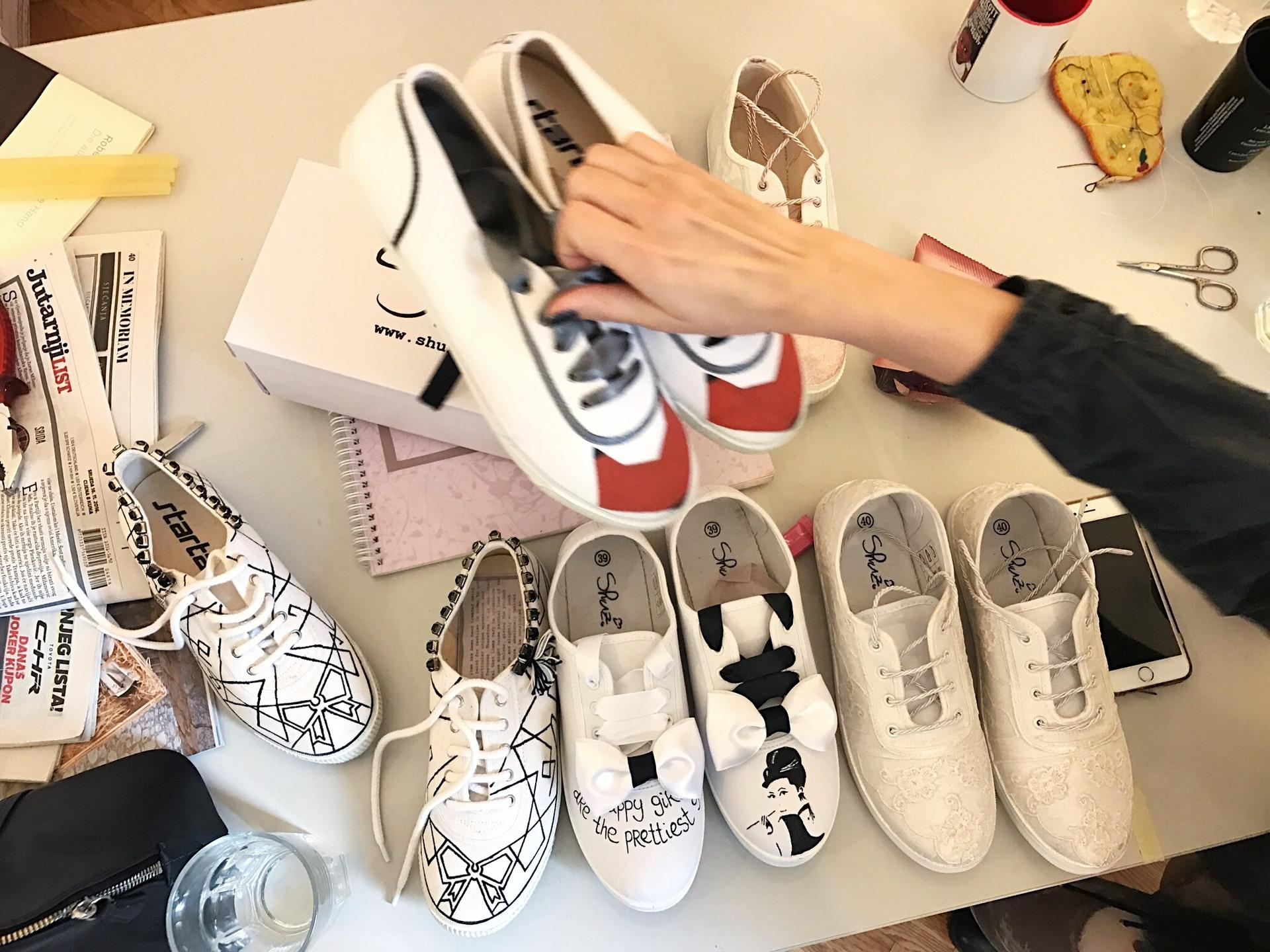 Maja Žirovčić rearranges the hand-painted shoes she's designed with co-founder, Ljudmila Mihajlović.
