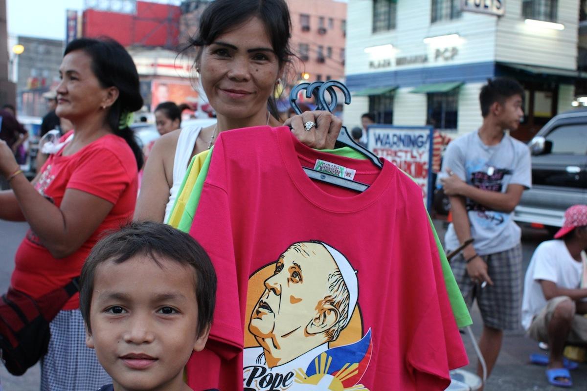A woman in Plaza Miranda, outside Quiapo Church in Manila, sells off her dwindling stock of Pope Francis t-shirts in advance of the Pope's visit to the Philippines.