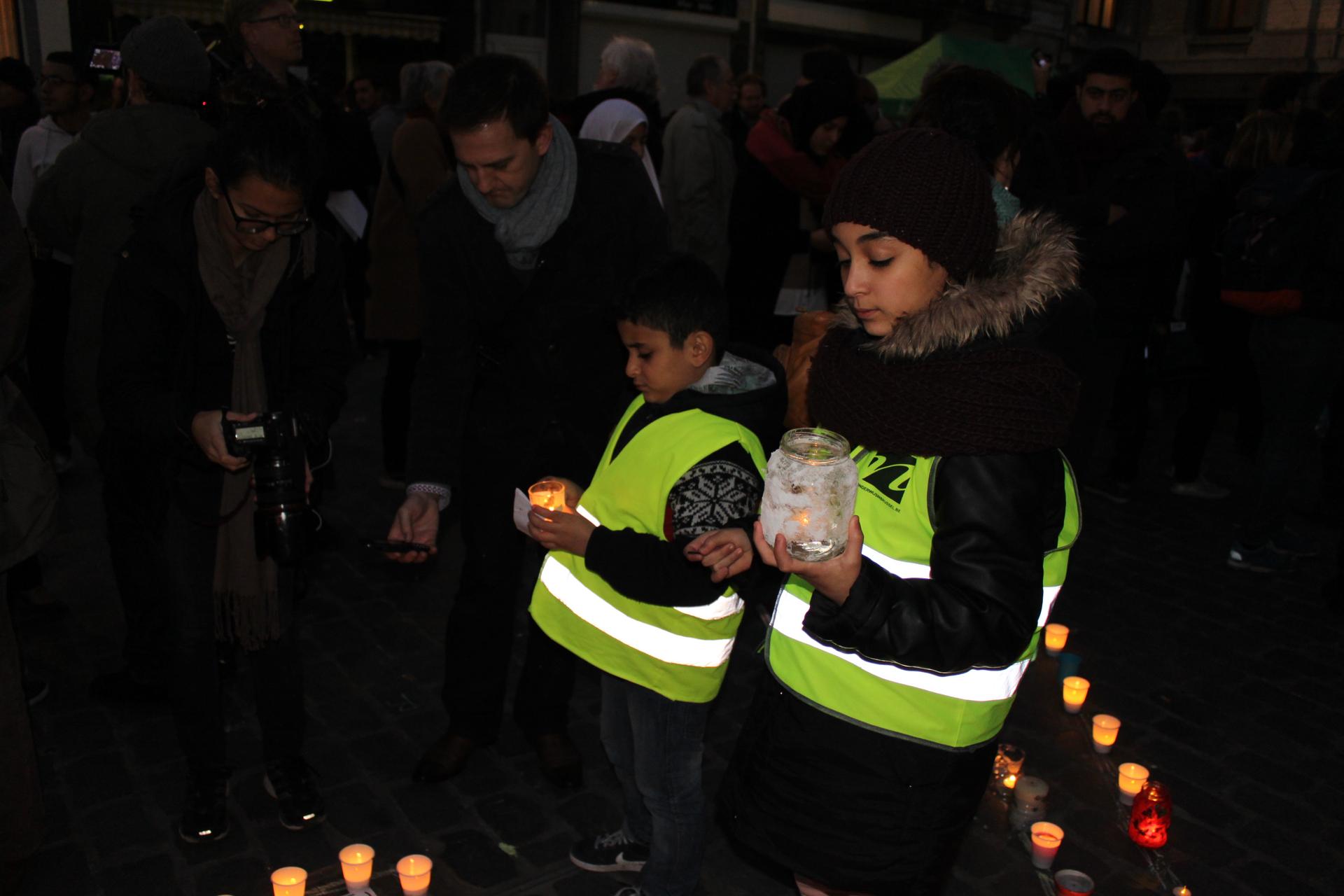 Children attend a candlelight vigil in the town square in Molenbeek, a neighborhood in Brussels with ties to the alleged perpetrators of the Paris attacks.