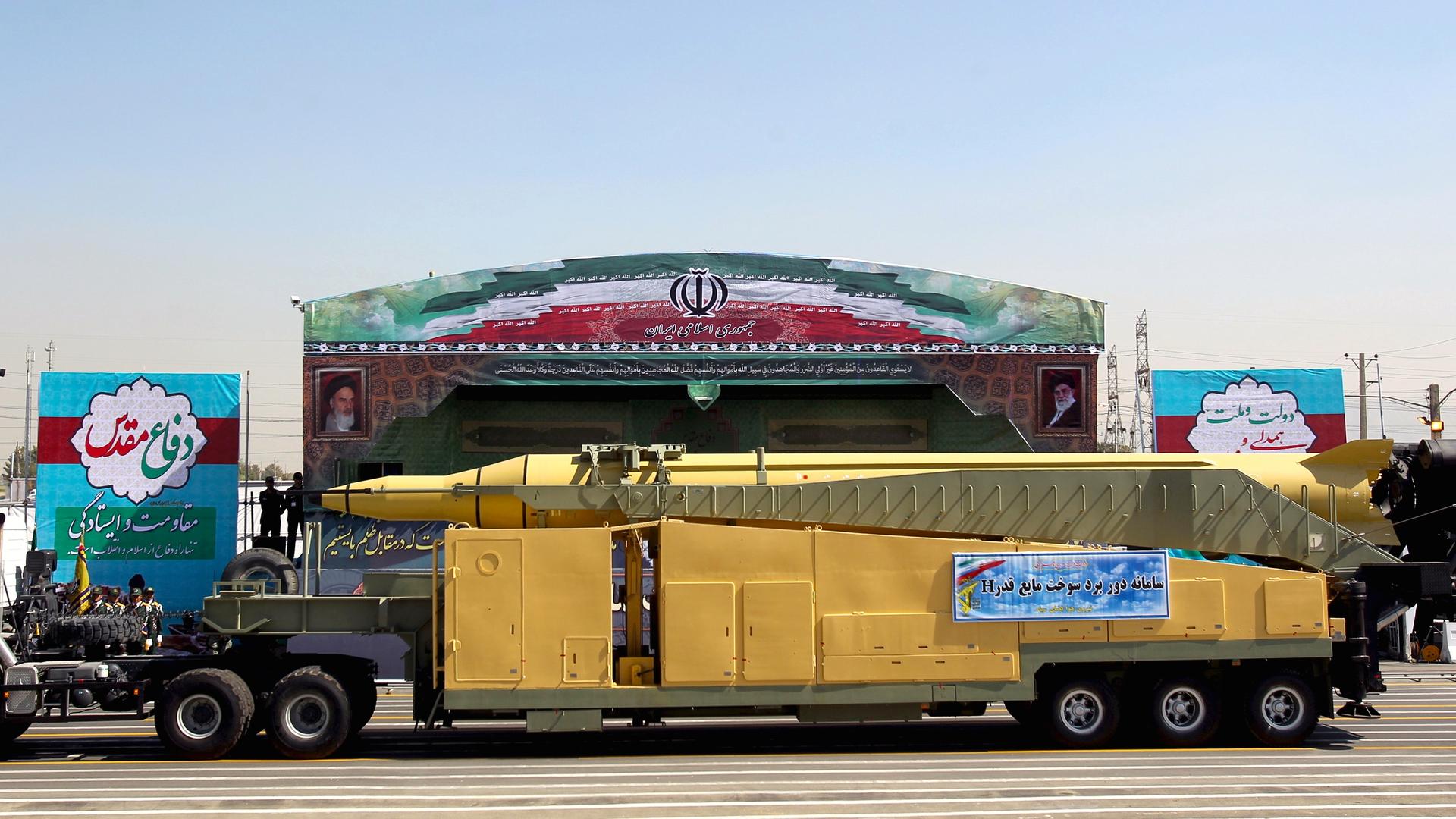 A military truck carrying a Qadr H missile drives past pictures of Iran's Supreme Leader Ayatollah Ali Khamenei (R) and late leader Ayatollah Ruhollah Khomeini during a parade marking the anniversary of the Iran-Iraq war (1980-88), in Tehran on September 