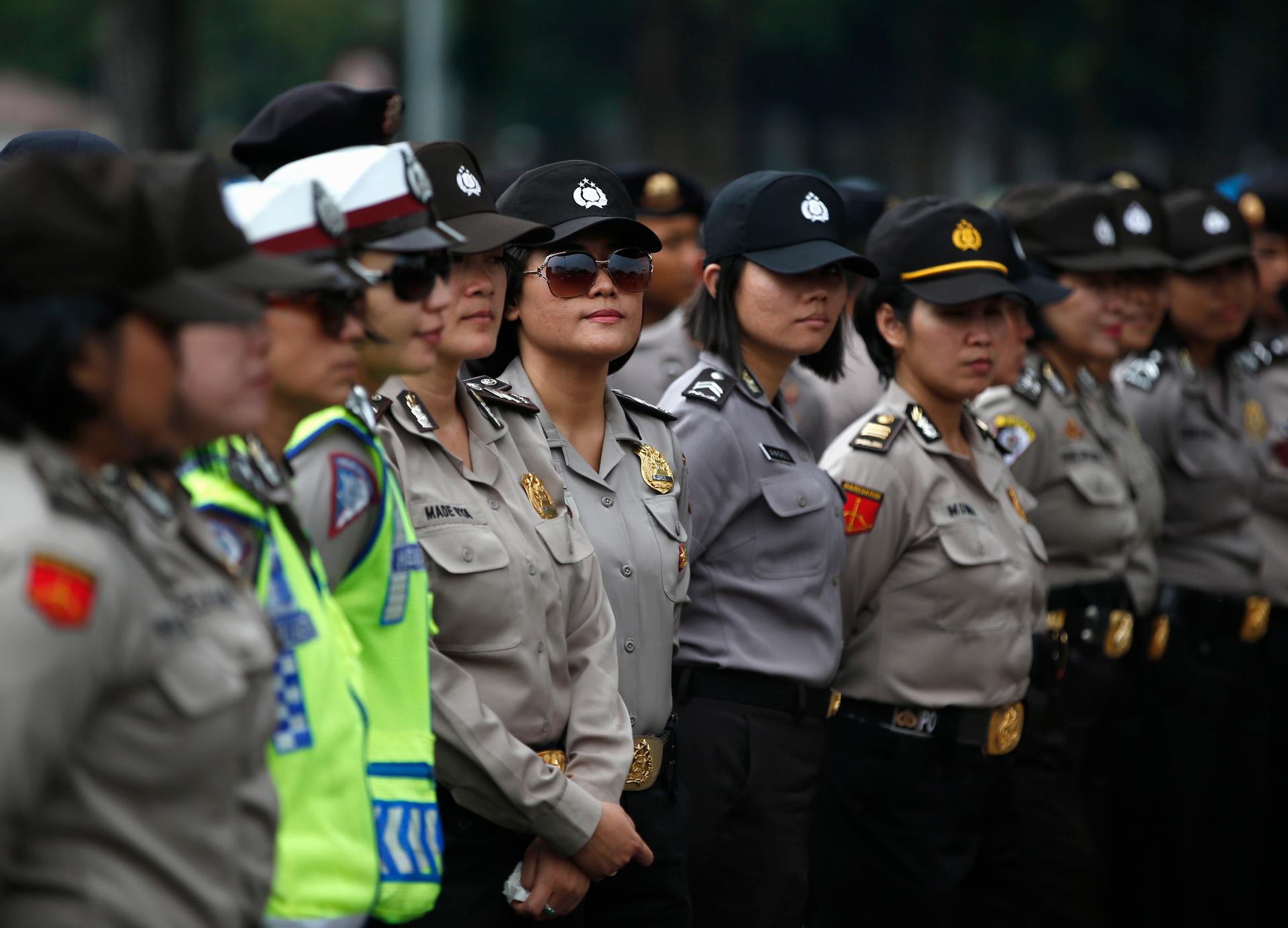Female Indonesian police officers stand guard outside the presidential palace during a protest against the recent fuel price hike in Jakarta on November 19th, 2014.