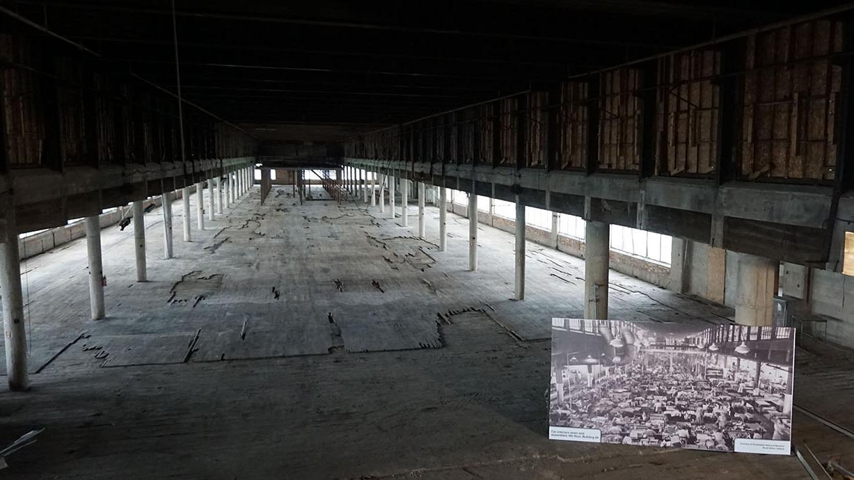 The sixth floor of the old Studebaker factory, about a fifth of a mile in length, in downtown Sound Bend, Indiana. A large cardboard photo shows the way the factory looked in the early 20th century, with almost 30,000 workers building cars at the Studebak