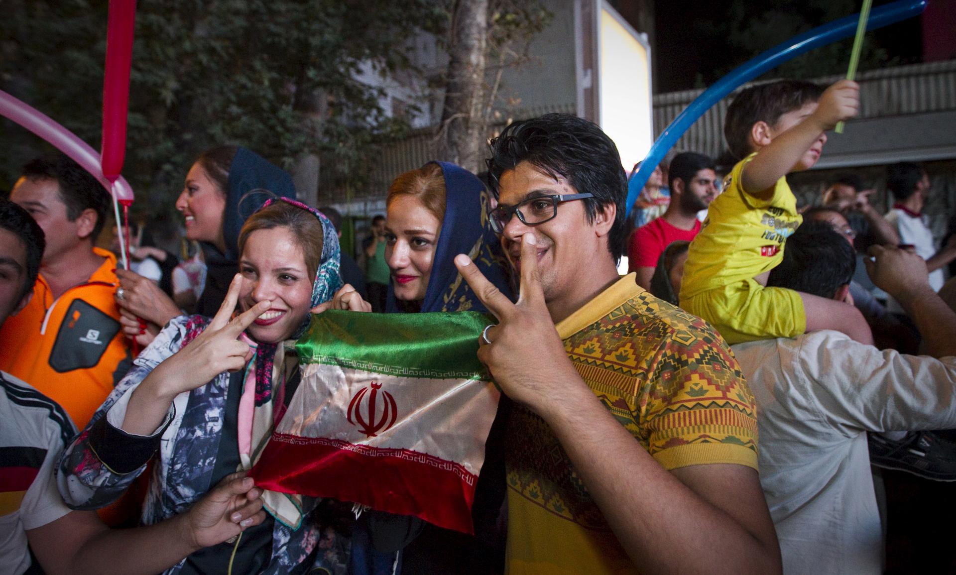 Iranians gesture as they celebrate in the streets of Tehran following the nuclear deal announced on July 14th. Iranian president Hassan Rouhani said a nuclear deal with major powers would open a new chapter of cooperation with the outside world after year