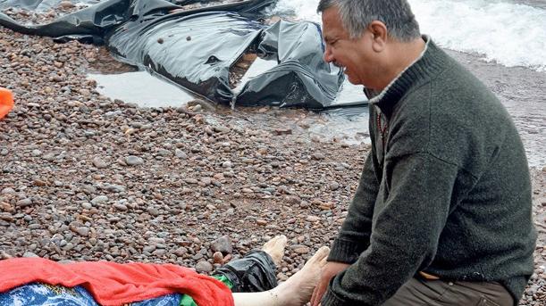 An Iraqi man mourns his wife on the beach on Lesbos on October 15, 2015.