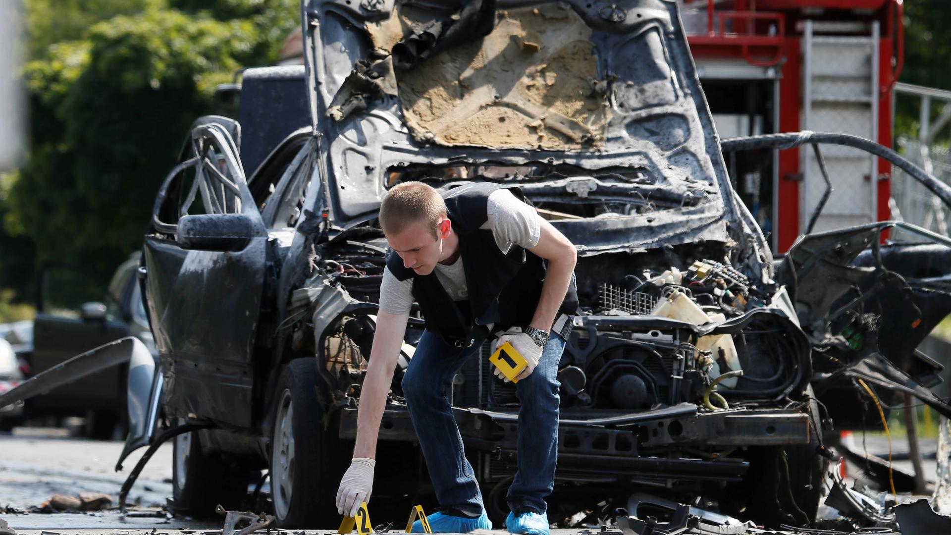 An investigator works at the scene of a car bomb explosion that killed Maksym Shapoval, a high-ranking Ukrainian official involved in military intelligence, in Kiev