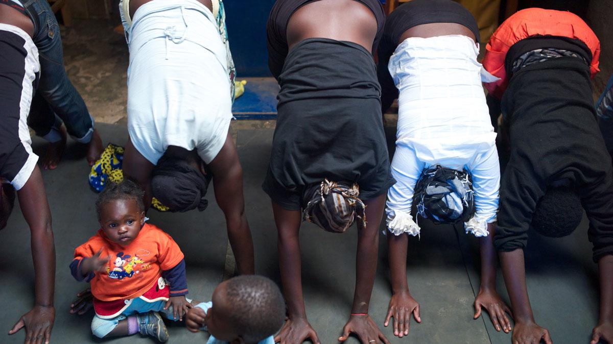 A yoga class for girls and young mothers in the slum of Kariobangi.  Mothers bring their kids to class.