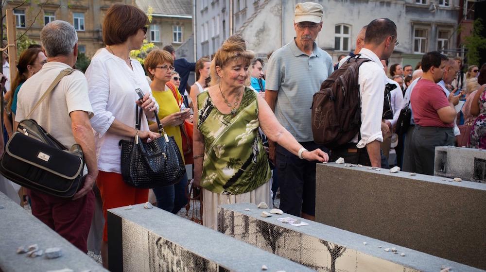 Visitors to the new Space of Synagogues memorial place stones in remembrance of the dead in Lviv, Ukraine on Sept. 4.