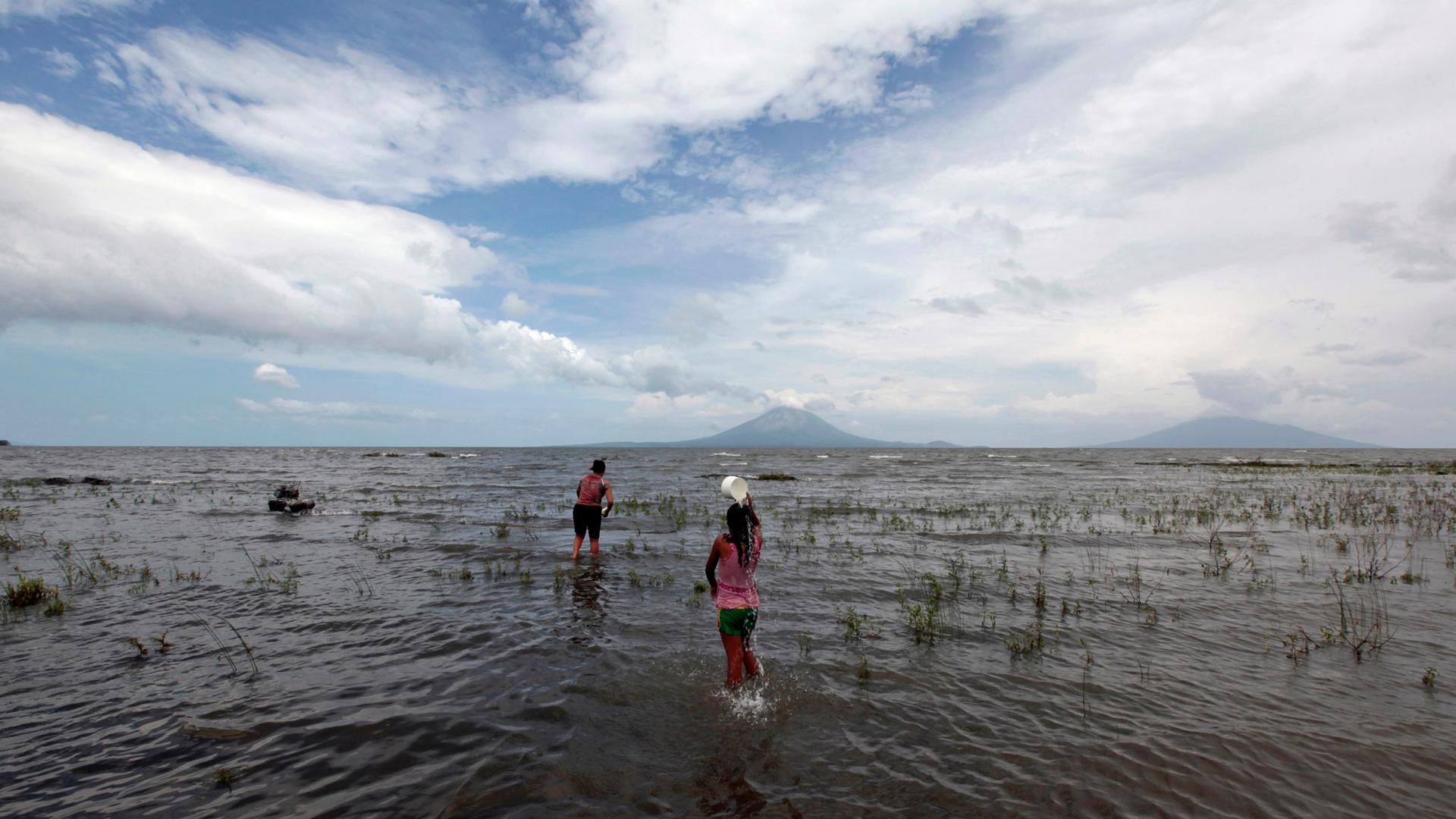 Local residents wade into the shallow waters of Lake Nicaragua, the largest in Central America, with the volcanic island of Ometepe in the distance. Many are worried that the lake will be contaminated by the country's new $50 billion Chinese-backed Pacifi