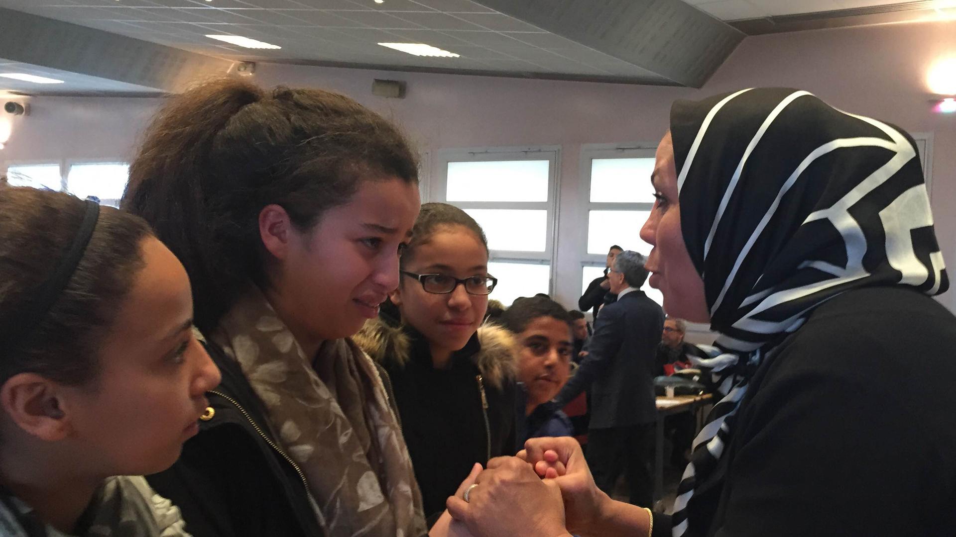 Latifa bin Ziaten (r) speaks with students about her son, Imad, who was murdered by Islamic extremist Mohamed Merah. At the end of her talk, students hug her. One girl says Latifah reminds her of her own mother.
