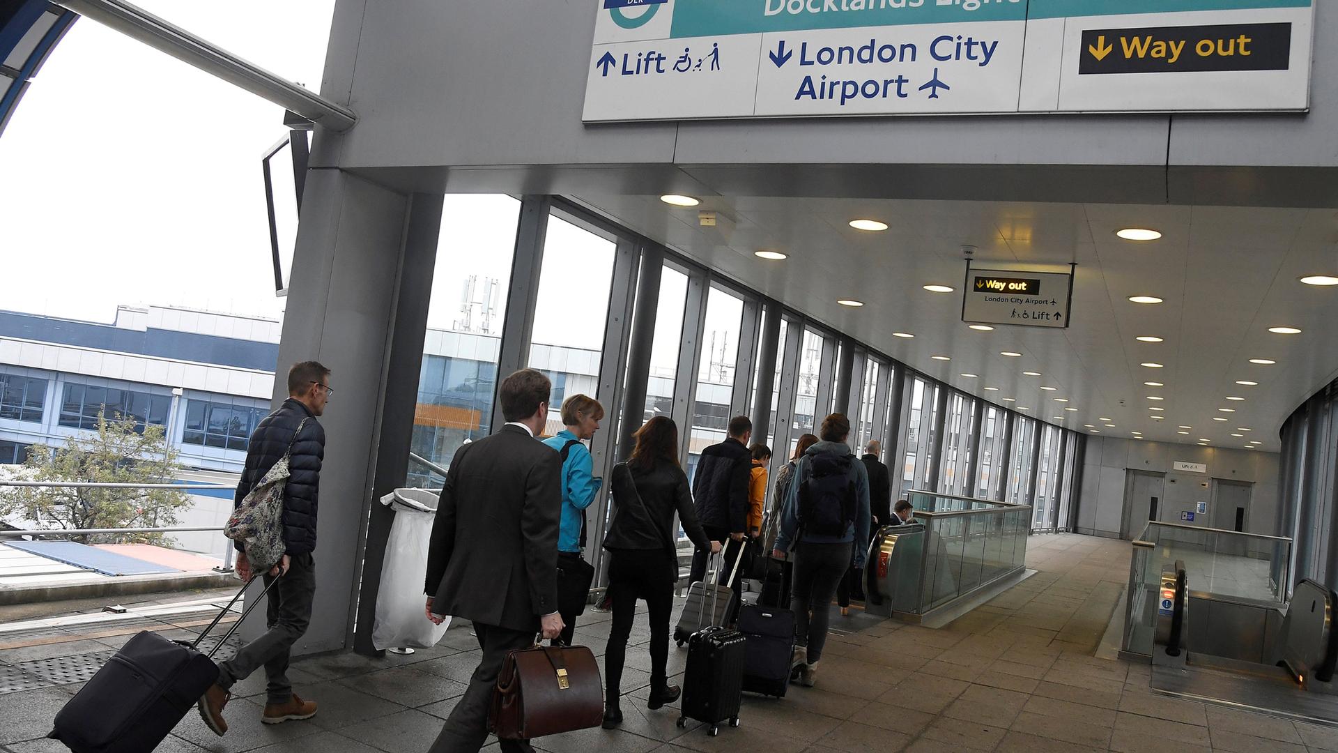 Passengers alight from a train to enter City Airport in London, Britain.