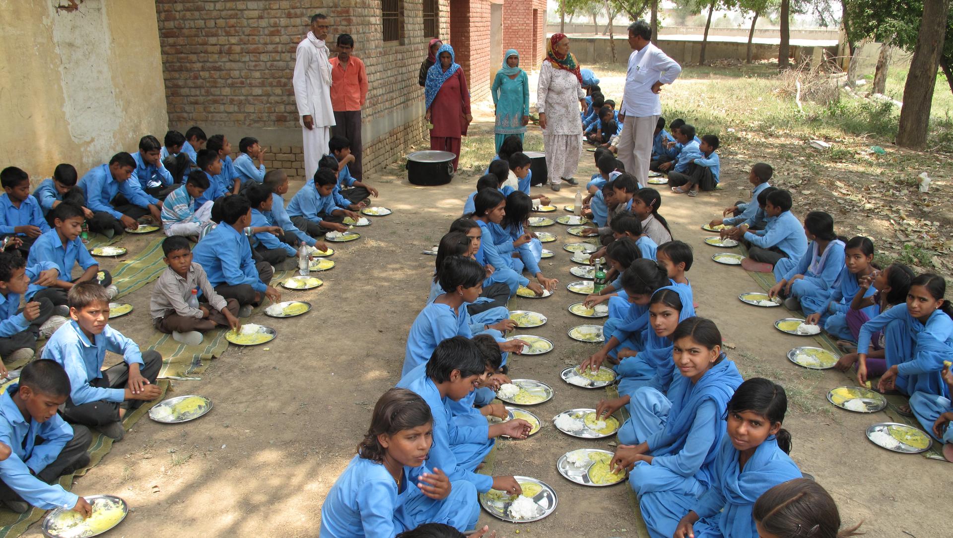 Schoolchildren in Haryana, India eat rice and kadhi, a curry made with onions, garlic, yogurt and fritters made with chick pea flour.