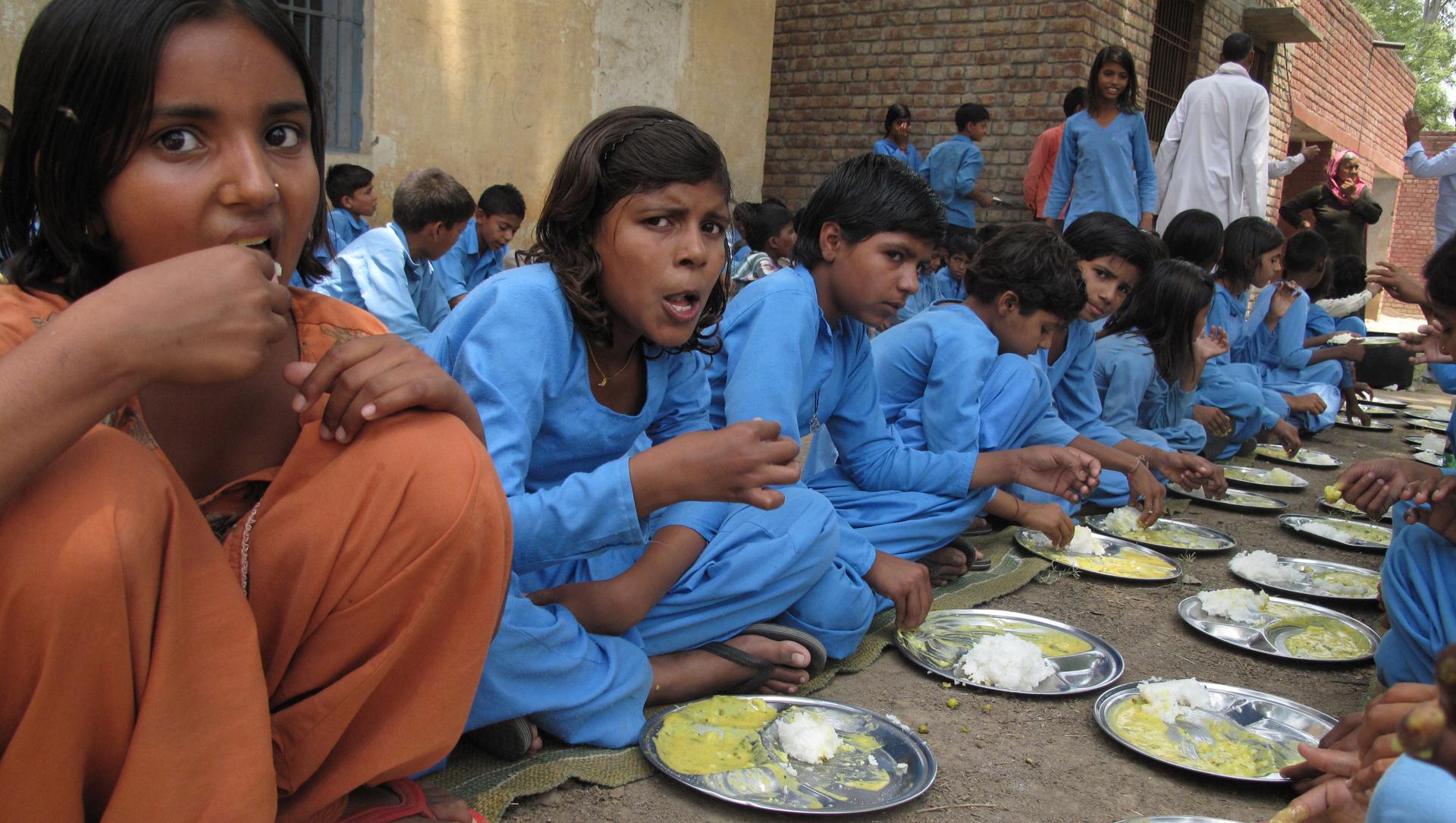 At a government school in Paposa, Haryana, children devour kadhi and rice.