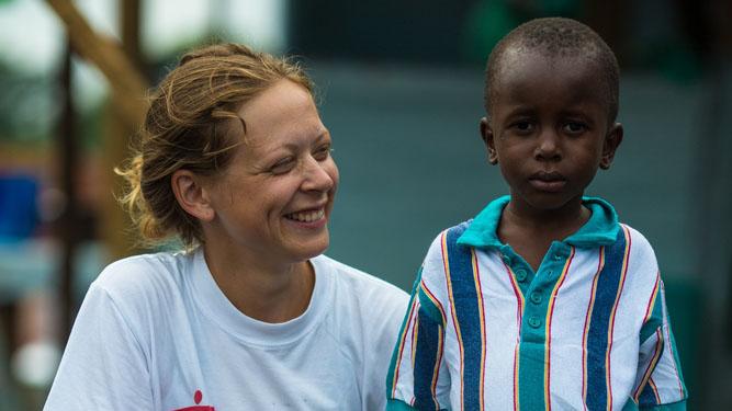 Ane Bjøru Fjeldsæter, an MSF Mental Health Manager from Norway, poses with six-year-old Ebola survivor Patrick.