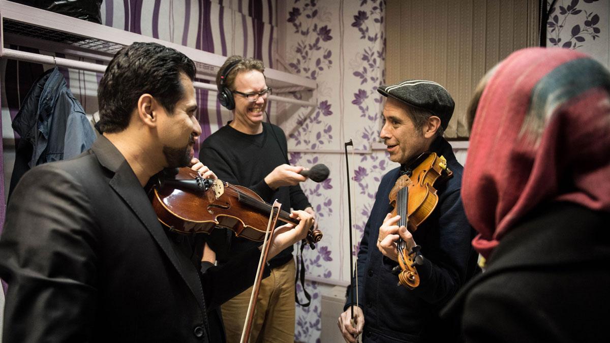 Arash Jame offers Marco Werman a violin lesson on Iranian scales.