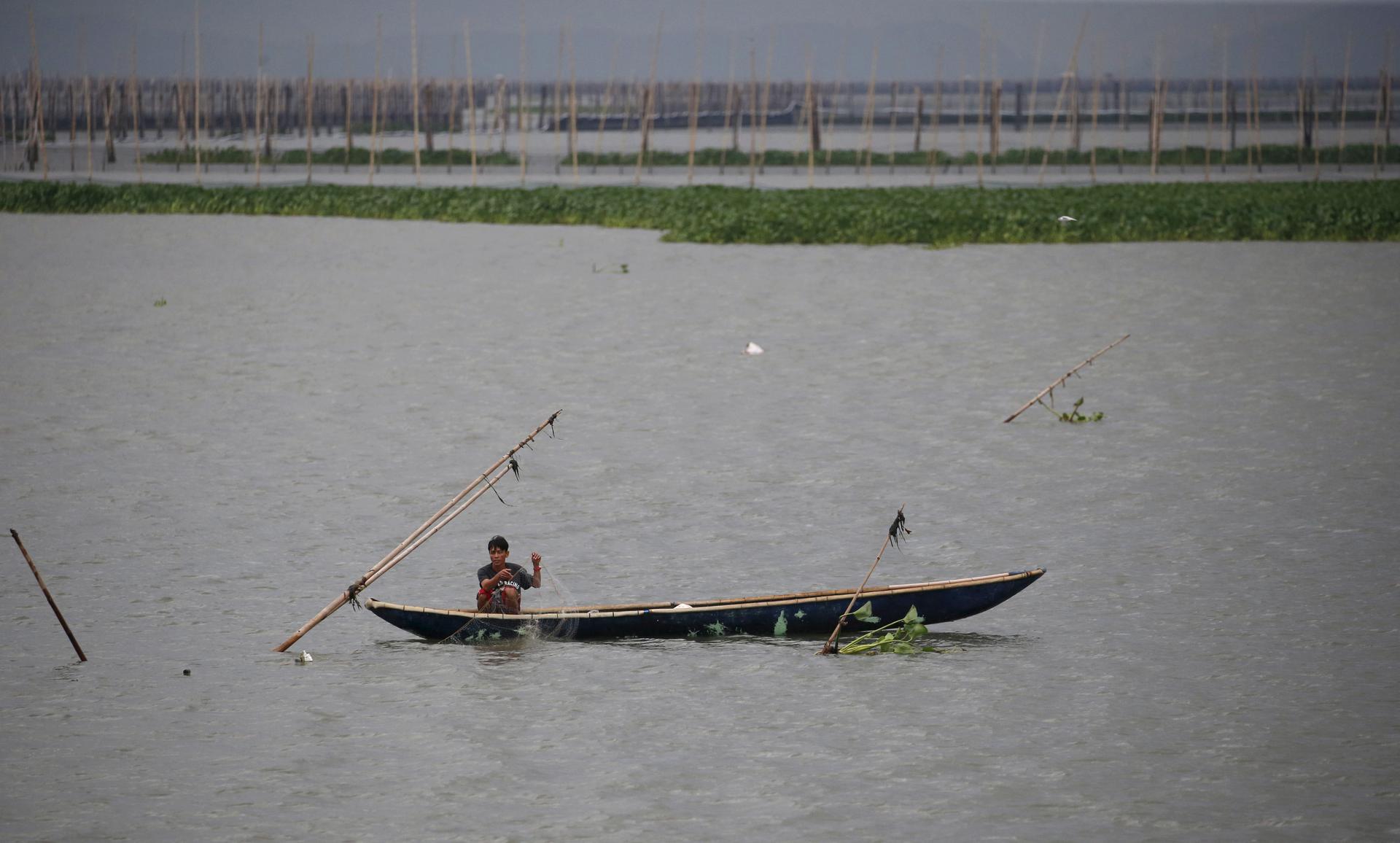 A resident fishes in the waters near Manila, Philippines, amid heavy current and winds brought by Typhoon Melor in some parts of the country. Wide areas of the central Philippines were plunged into darkness on Tuesday as Melor barreled into the coconut-gr