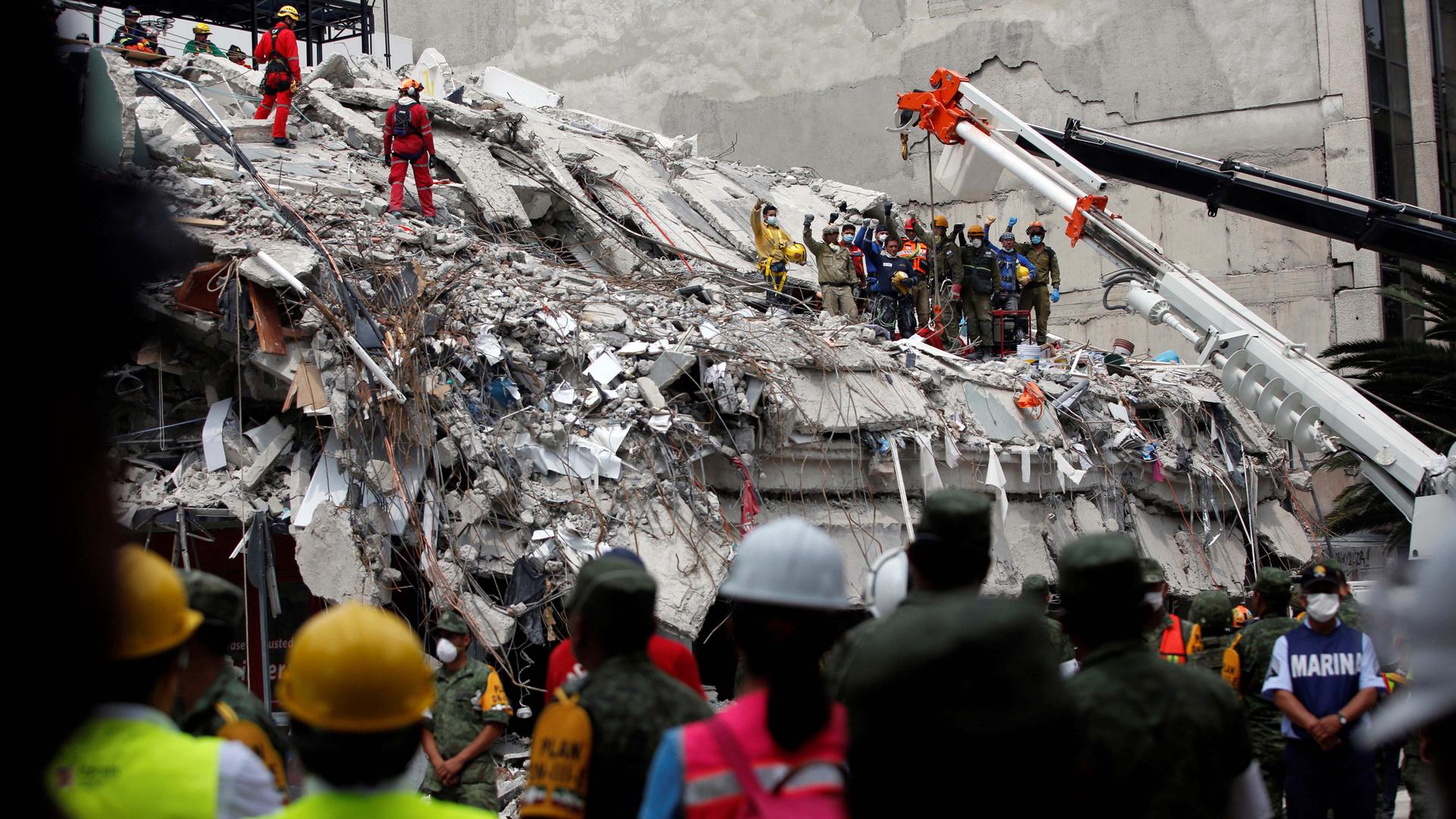 Members of Israeli and Mexican rescue teams gesture for a minute of silence after retrieving a dead body from a collapsed building after an earthquake in Mexico City, Mexico, on Sept. 21, 2017.