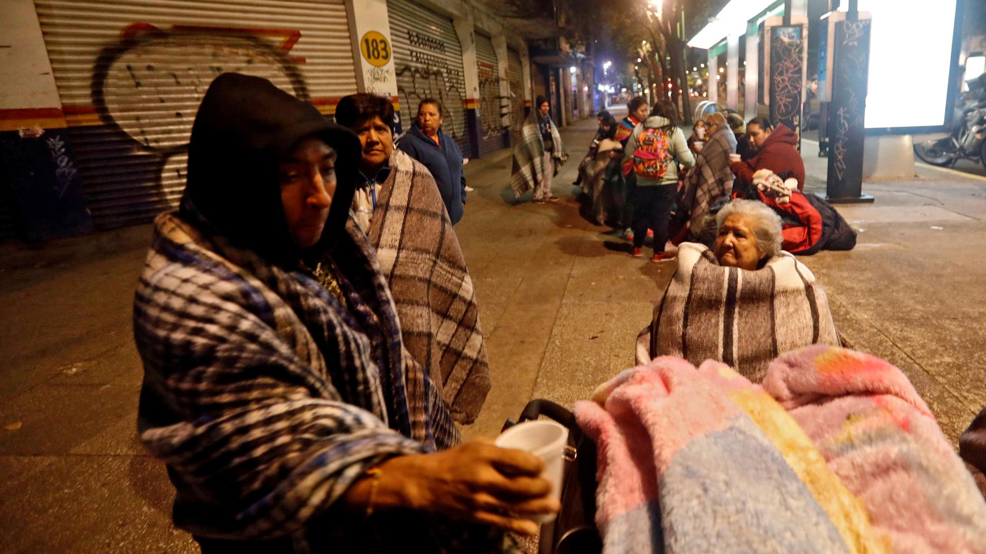 People gather on a street after an earthquake hit Mexico City.