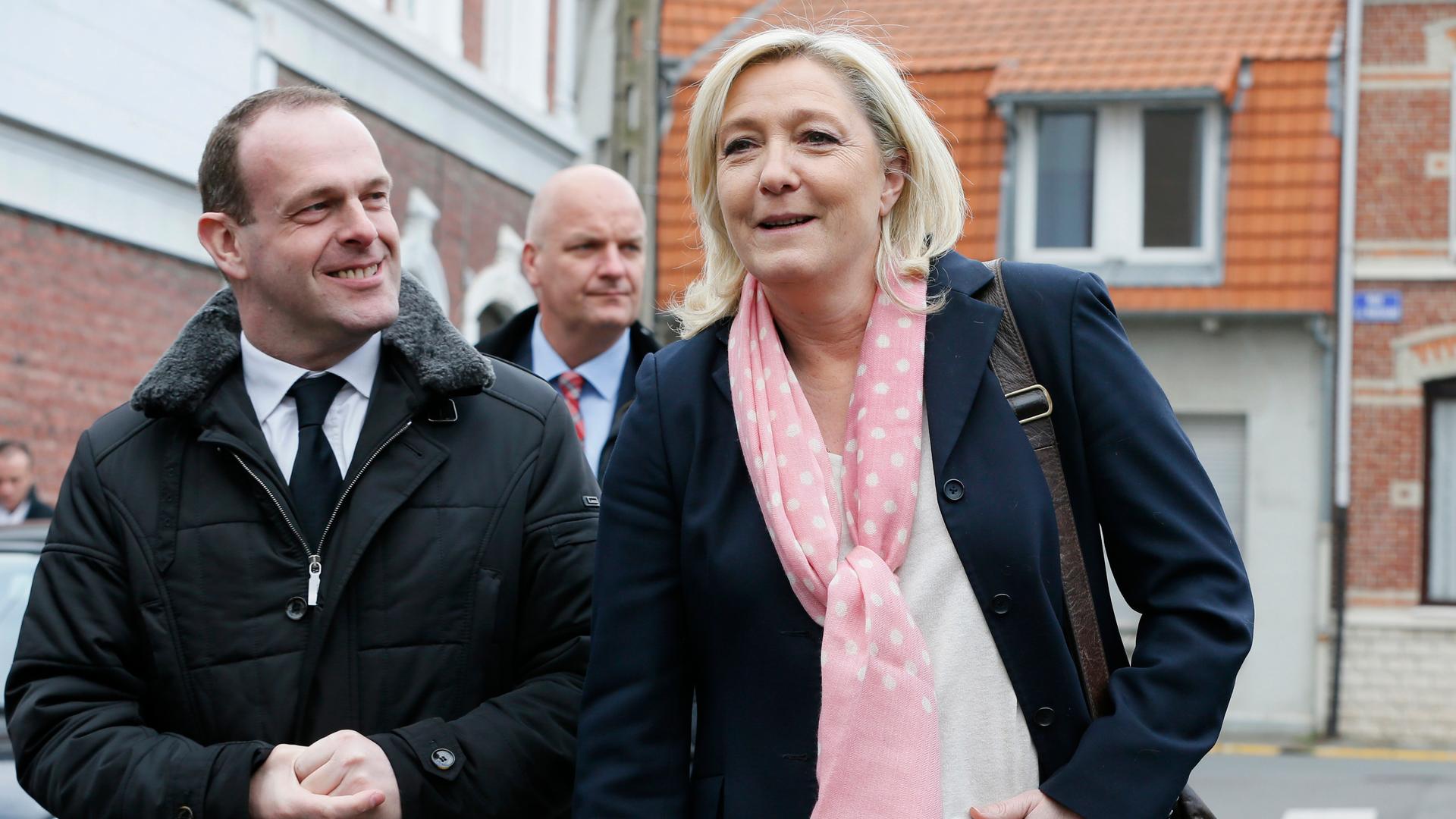 France's far-right National Front leader, Marine Le Pen (R), and Mayor of Henin-Beaumont, Steeve Briois, leave a polling station, March 2015.