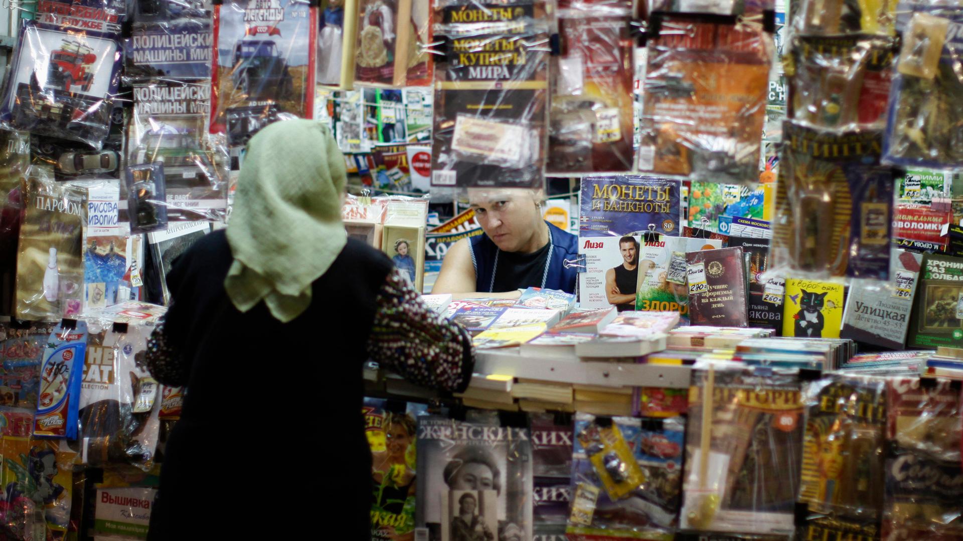 A woman works at a news-stand in the Moscow metro.