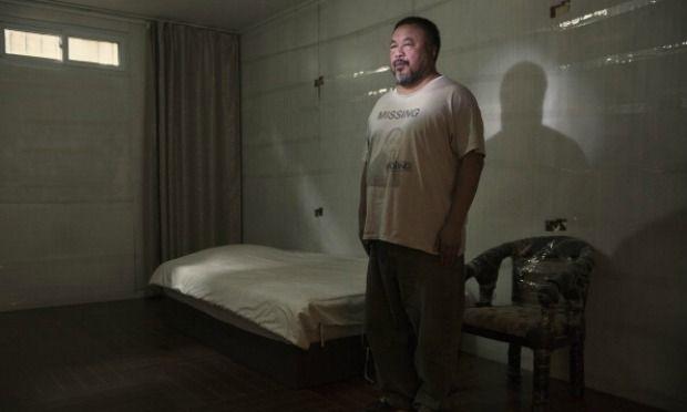 Artist Ai Weiwei stands in an exact replica of the cell where he was detained by the Chinese government for roughly three months in 2011.