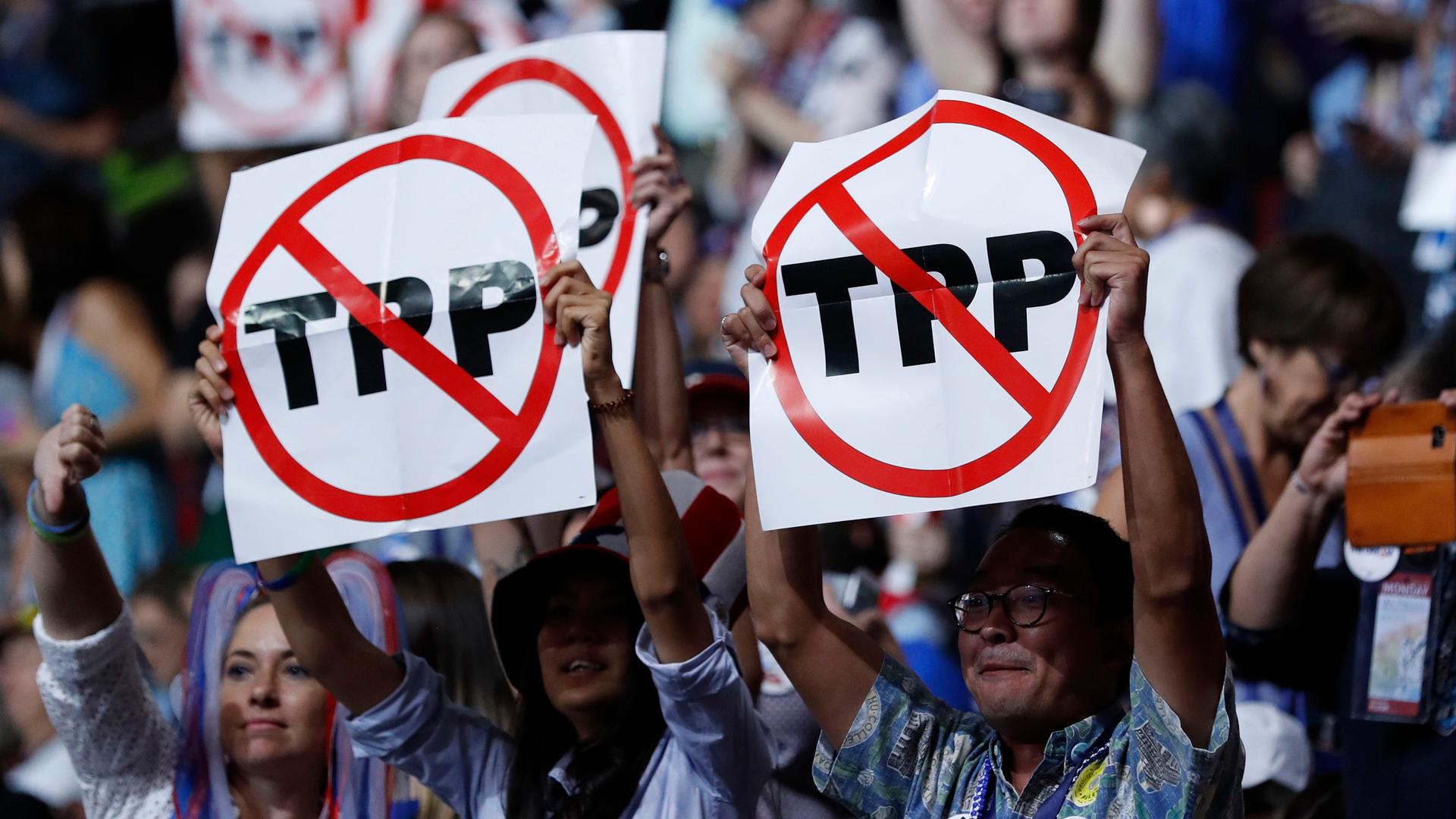 Delegates protesting against the Trans Pacific Partnership (TPP) trade agreement hold up signs during the first sesssion of the Democratic National Convention in Philadelphia. , Pe