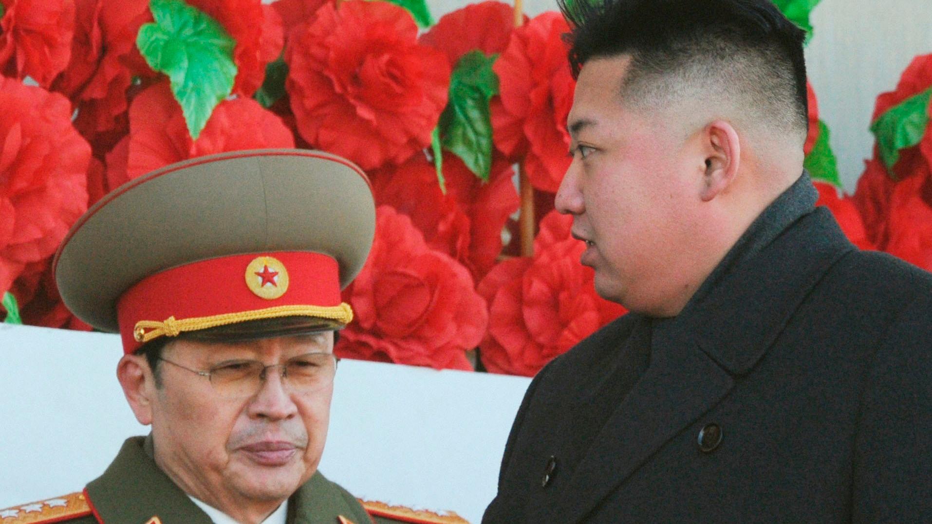 Jang Song-thaek in army uniform standing with his nephew and North Korea's top leader, Kim Jong-un, at a military parade in Pyongyang (February of 2012). 