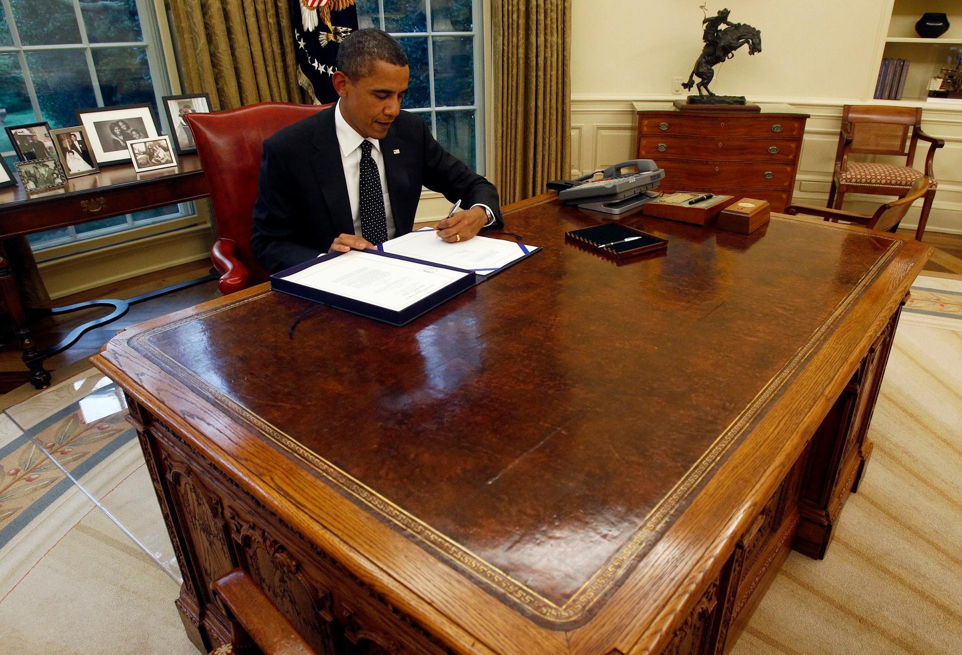 President Barack Obama at his desk in the Oval Office at the White House. 