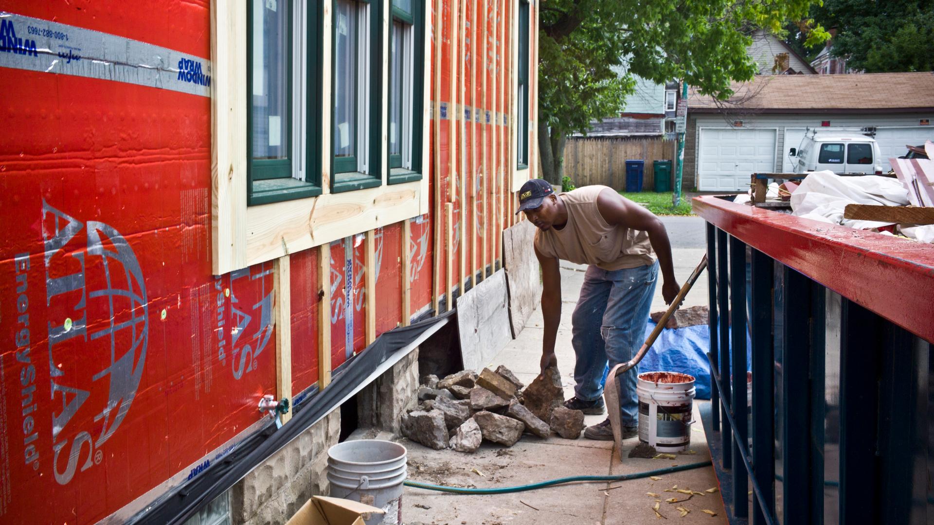 A worker with the community organization PUSH Buffalo weatherizes a home on Buffalo's lower west side. The formerly vacant home was completely rehabbed — with solar panels and other-energy efficient features — and is now rented to a low-income family. 