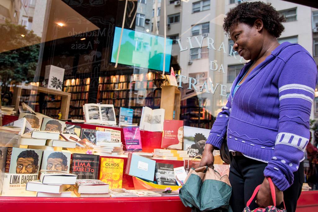 A woman in Brazil surveys a diverse display of books in a bookshop