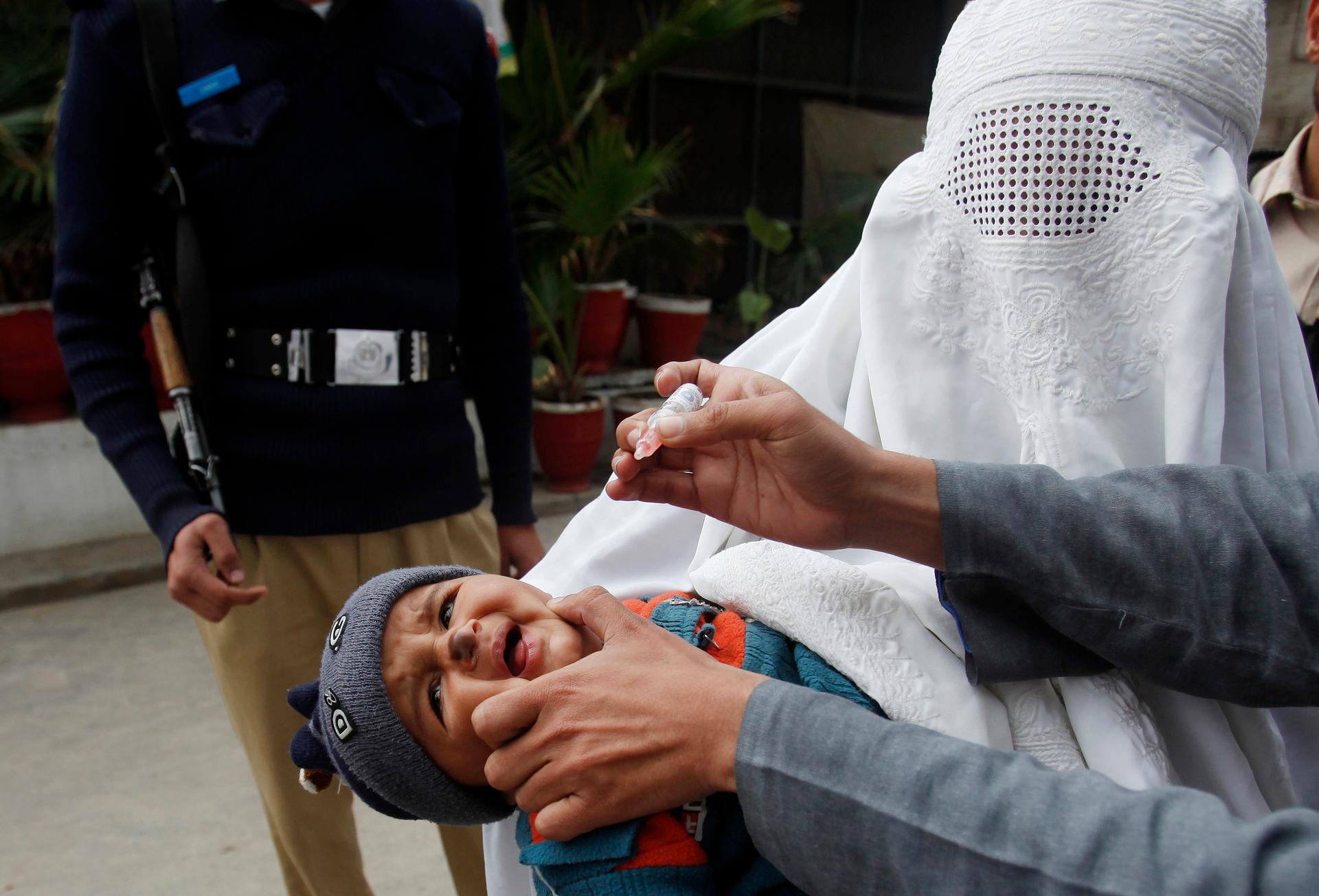 A girl cries before receiving polio vaccine drops at a government children's hospital in Peshawar on March 3, 2015. Pakistan authorities have arrested hundreds of parents who refuse to vaccinate their children against polio.