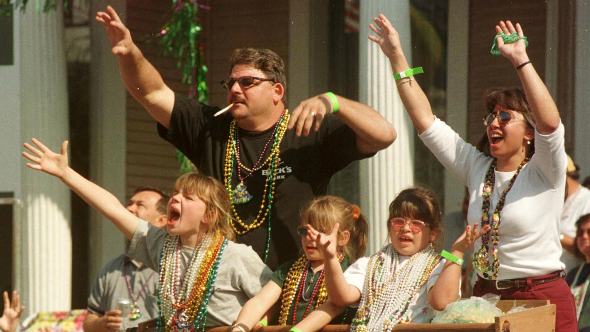 Revelers catch Mardi Gras beads during the Krewe of Thoth parade down St. Charles Avenue in New Orleans, March 5, 2000.