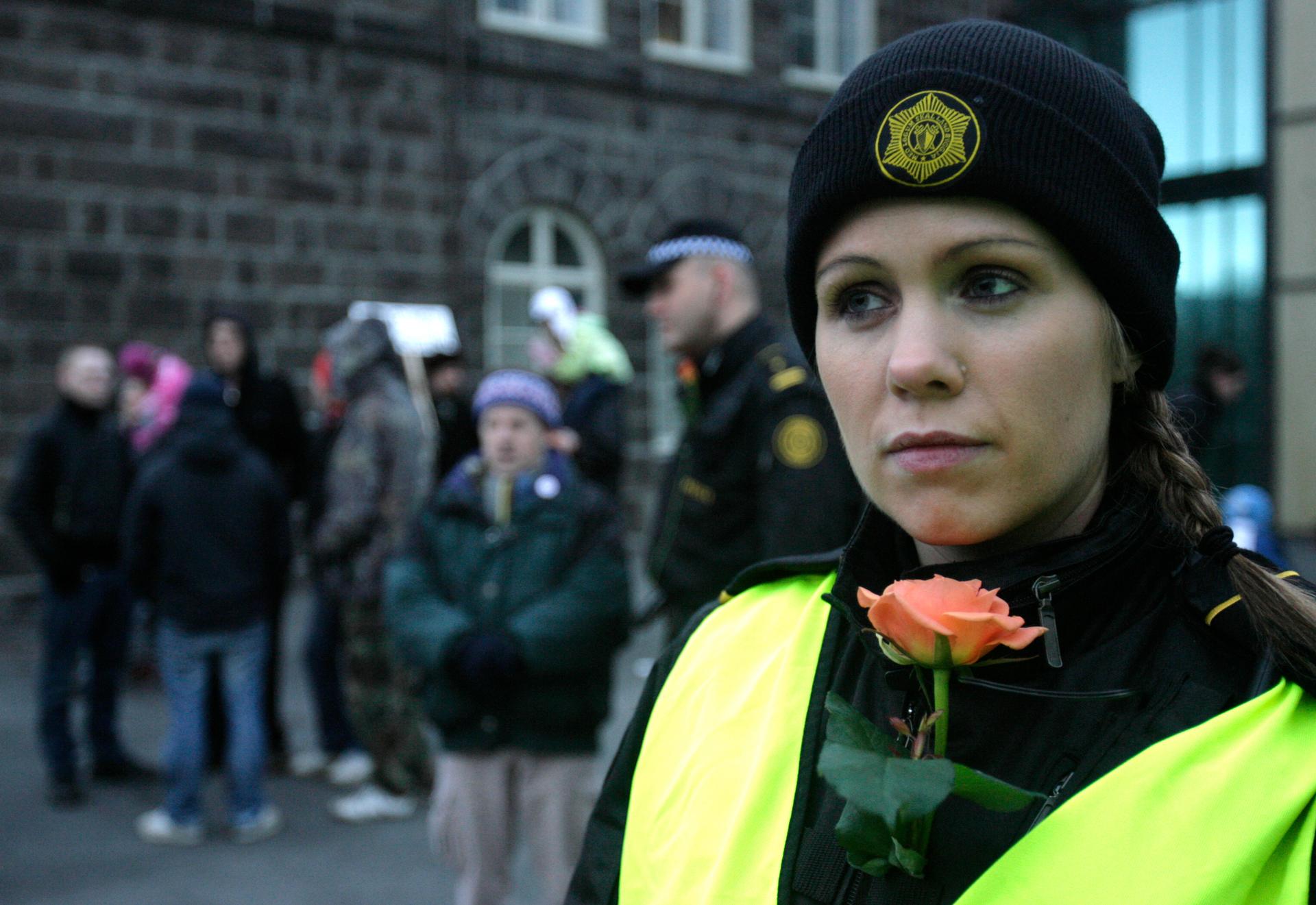 An Icelandic police officer stands guard at a peaceful protest near Iceland's Parliament house in Reykjavik 
