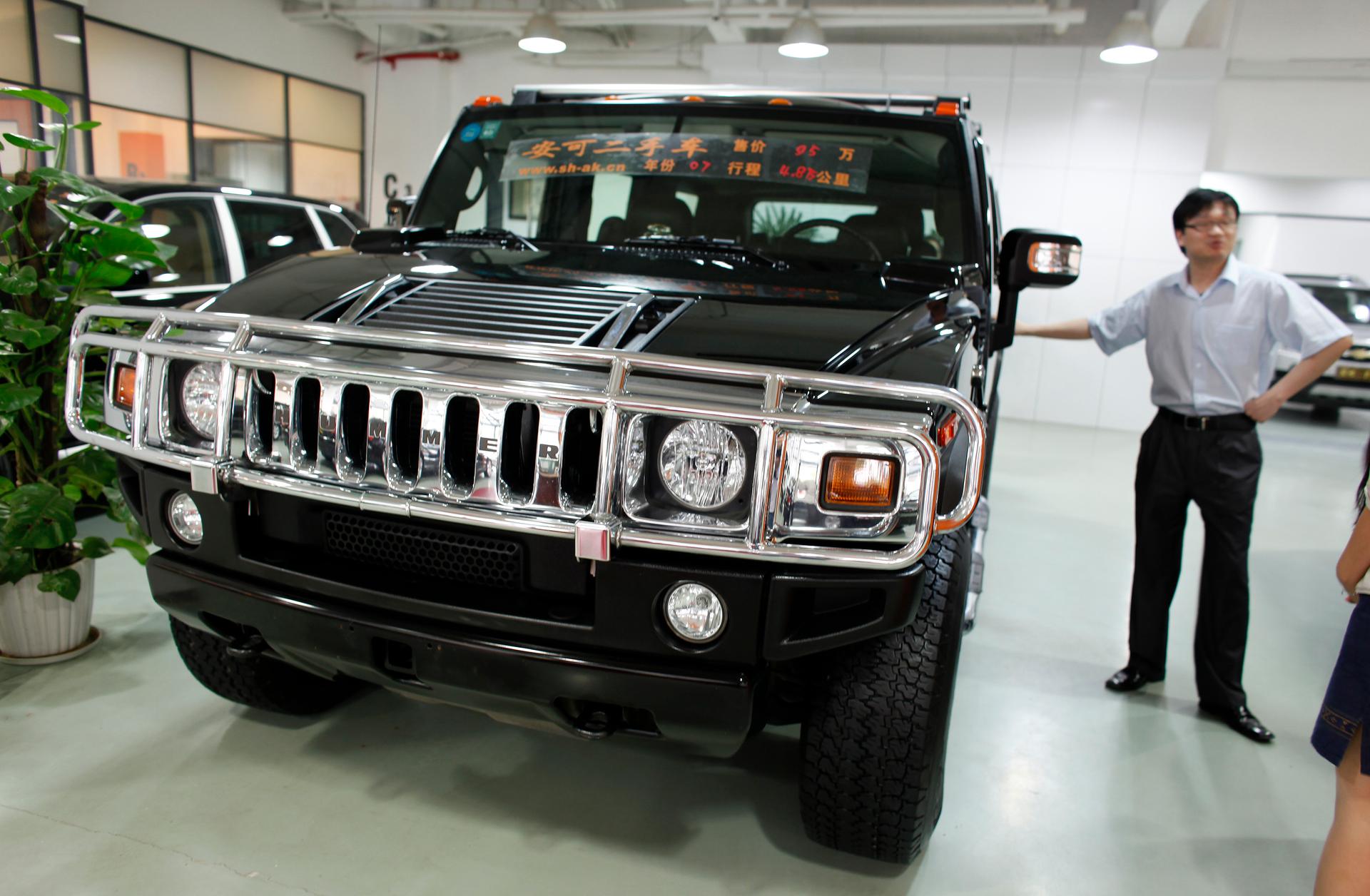 A salesman stands next to a Hummer for sale at an auto trading center in Shanghai on June 3, 2009. 