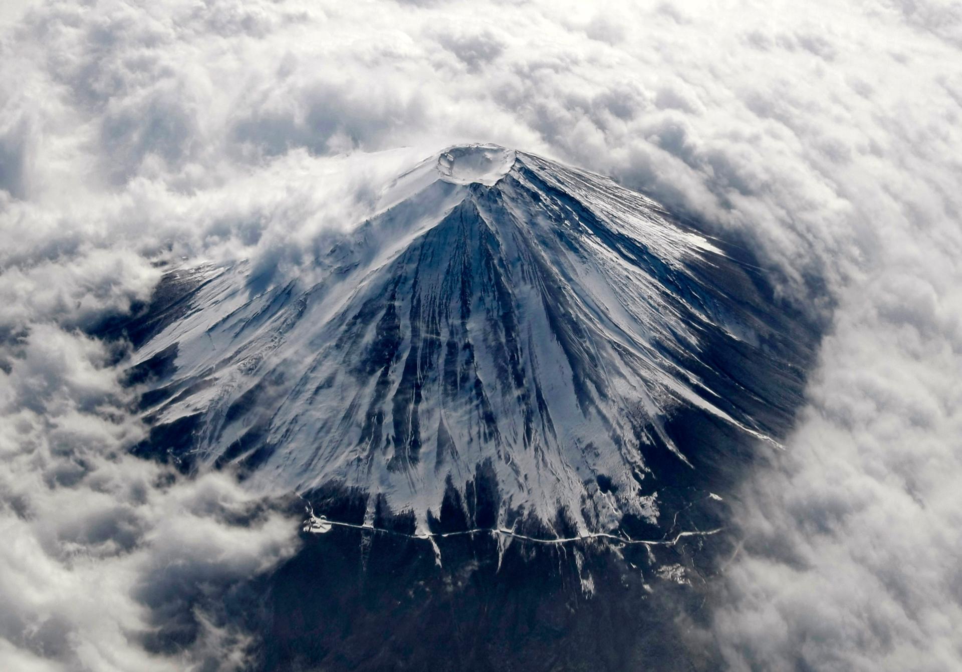 Japan's Mount Fuji, covered with snow and surrounded by cloud, is seen from an airplane February 2, 2010. Mount Fuji, at 3,776 metres (12,388 ft) is Japan's highest mountain. 