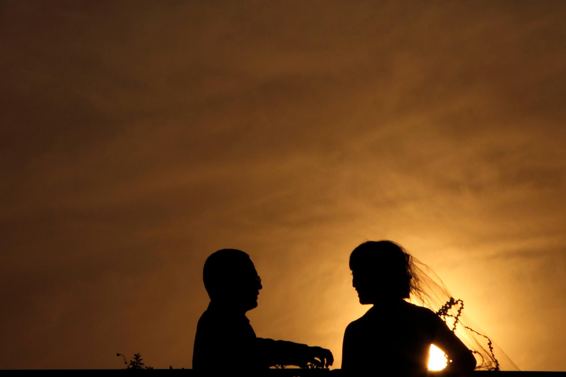 A silhouetted bride and groom