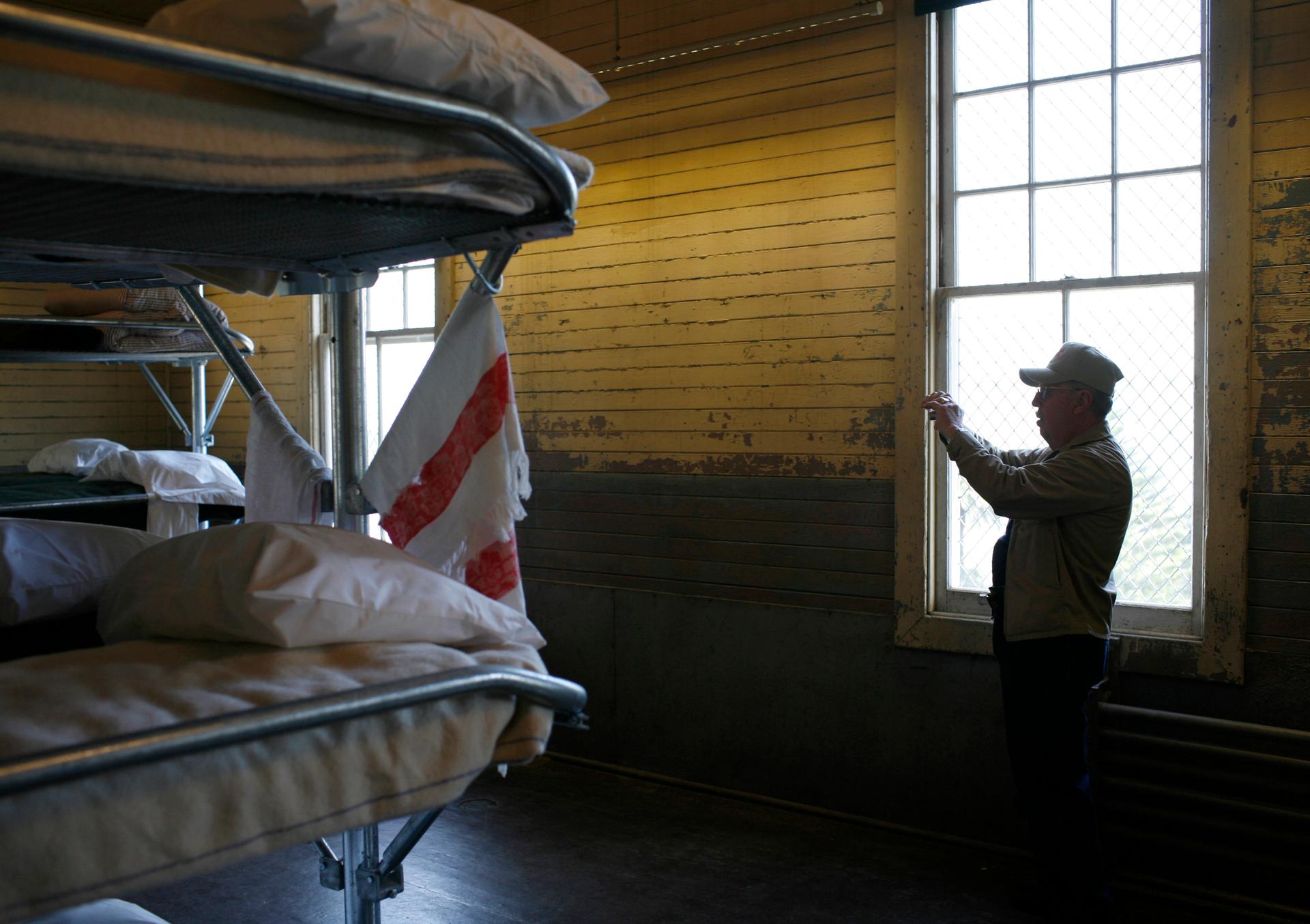 Bunk beds in cell, with man taking photo will cell phone