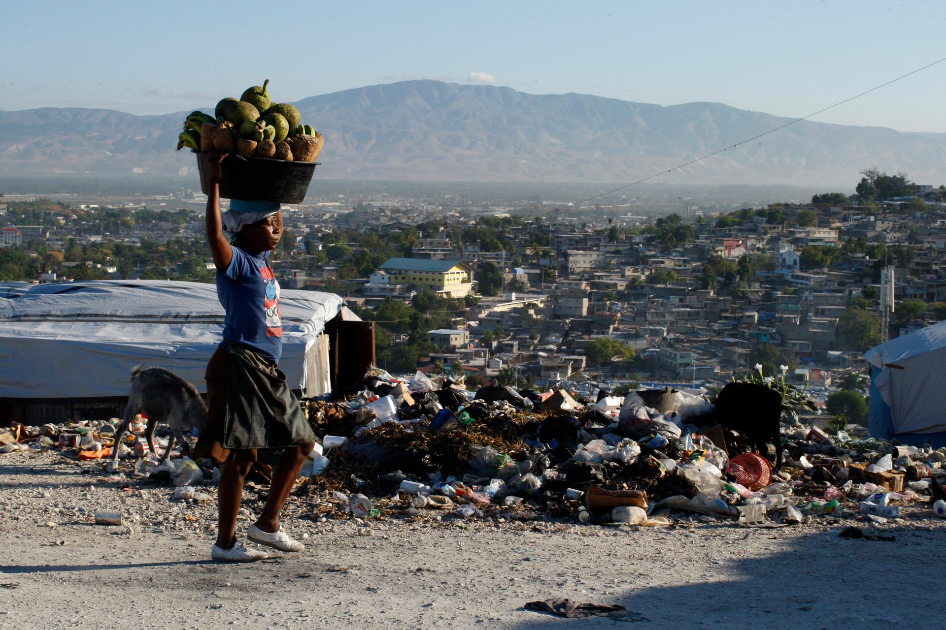 A Haitian woman carries produce to be sold in Port-au-Prince on March 15, 2011. An estimated three million people were affected by the earthquake in 2010.
