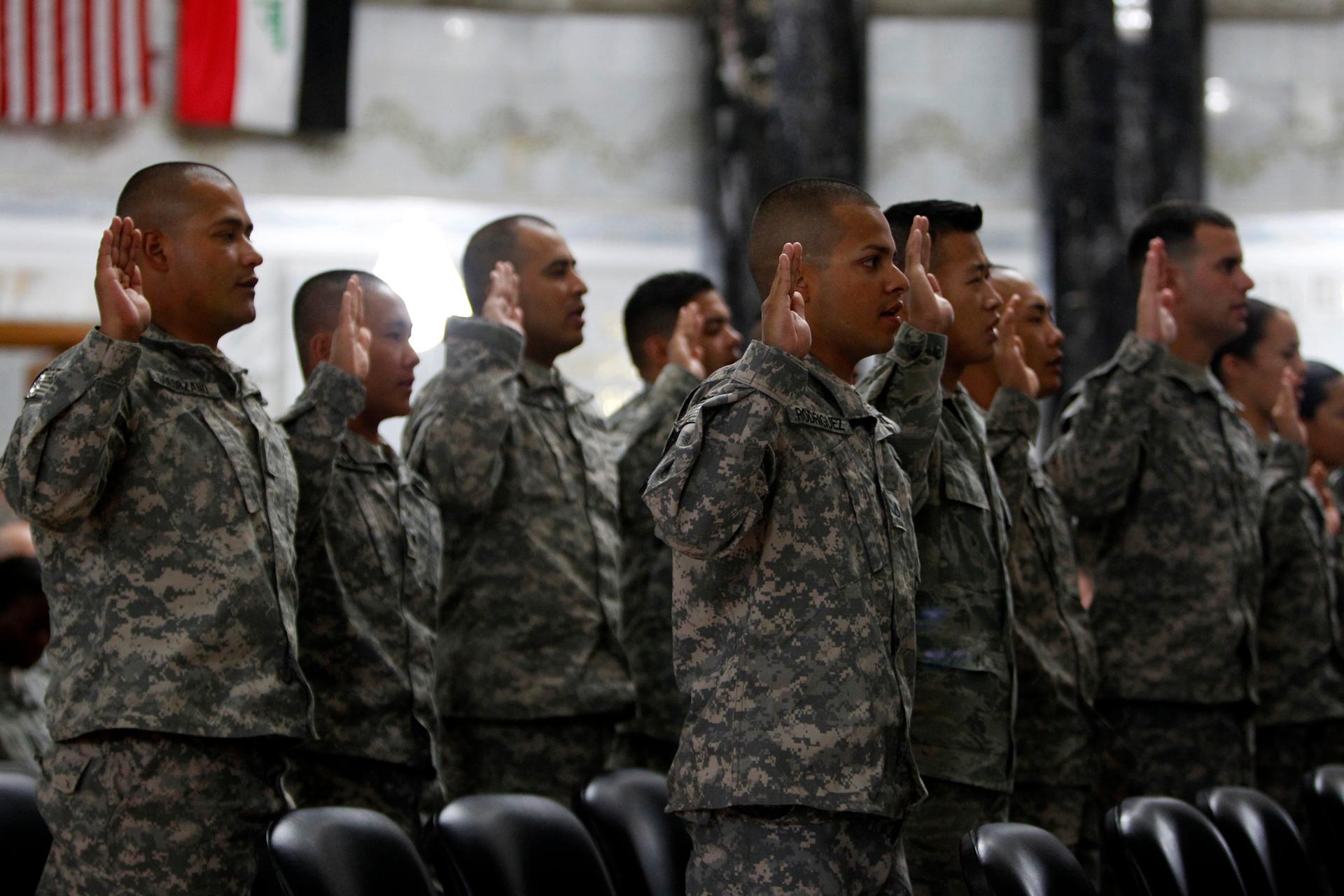 Servicemen from the US military take an oath during a naturalization ceremony at the Al-Faw Palace in Baghdad's Camp Victory on July 4, 2011.