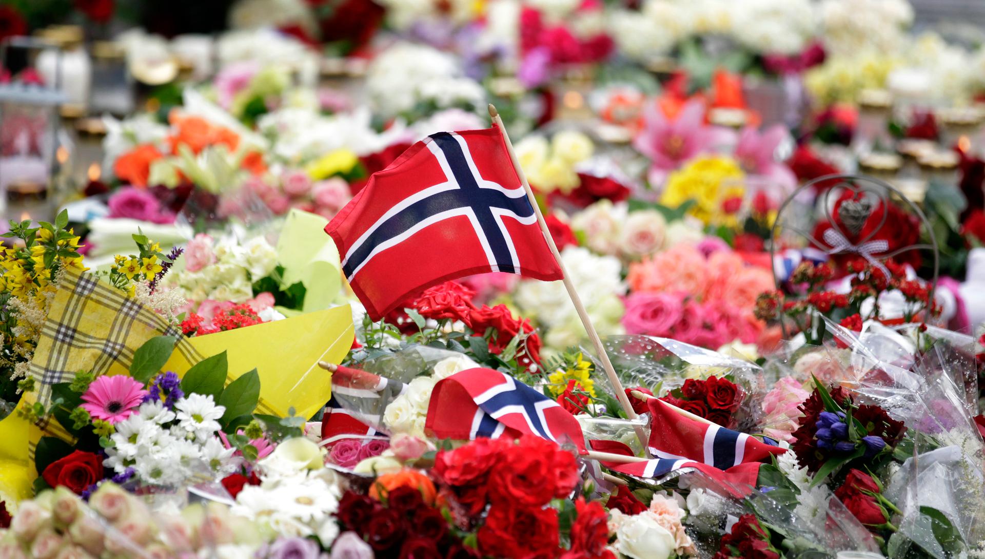 A Norwegian flag is placed amongst floral tributes outside the Oslo cathedral July 24, 2011. A right-wing zealot who admitted to bomb and gun attacks in Norway that killed 92 people on Friday claims he acted alone, Norway's police said on Sunday.