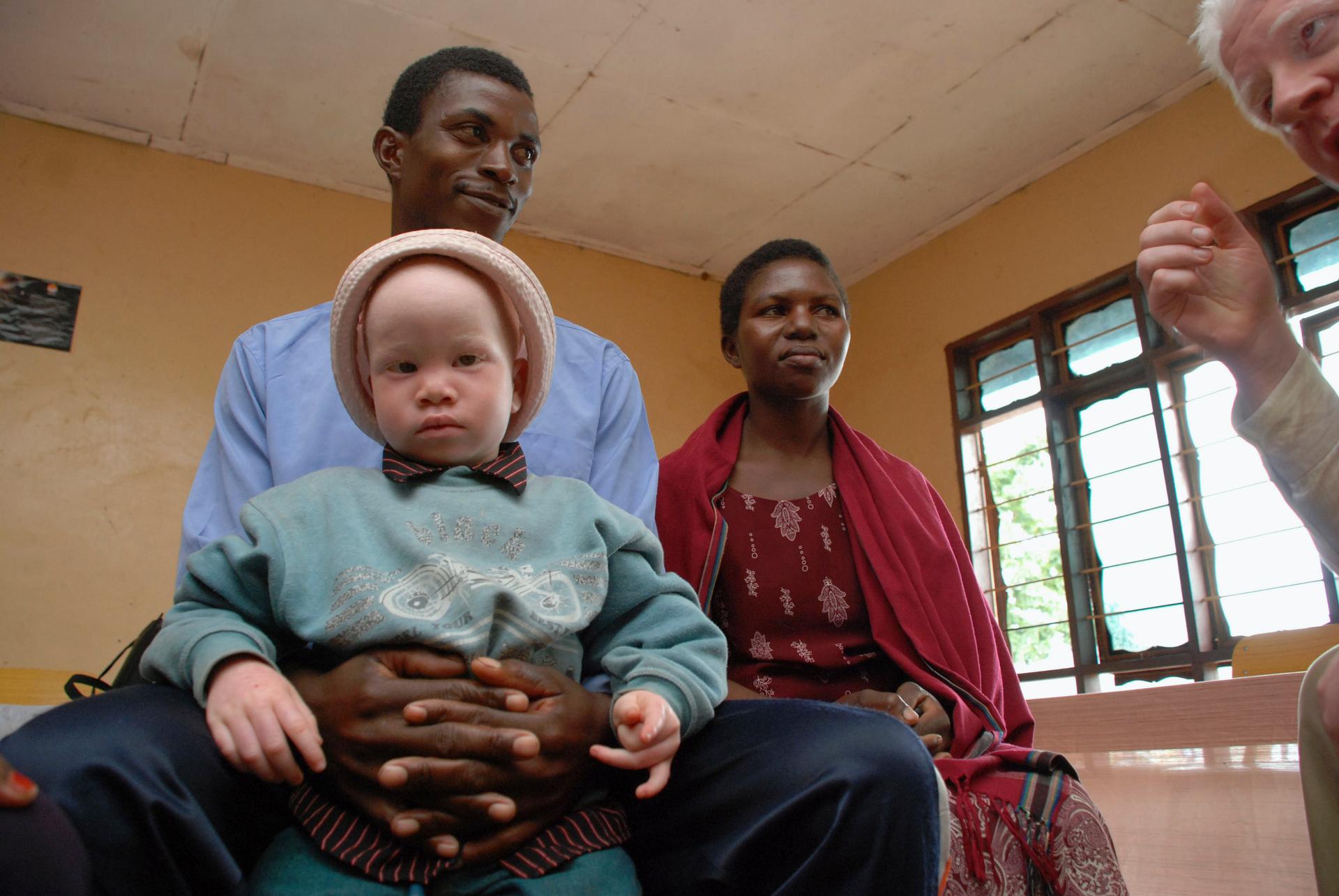 Elias Stariko (L) sits next to wife Farida Bwire, as he holds their son at the Golden Valley English Medium School, a school sponsored by Under the Same Sun (UTSS), in Geita November 24, 2011.