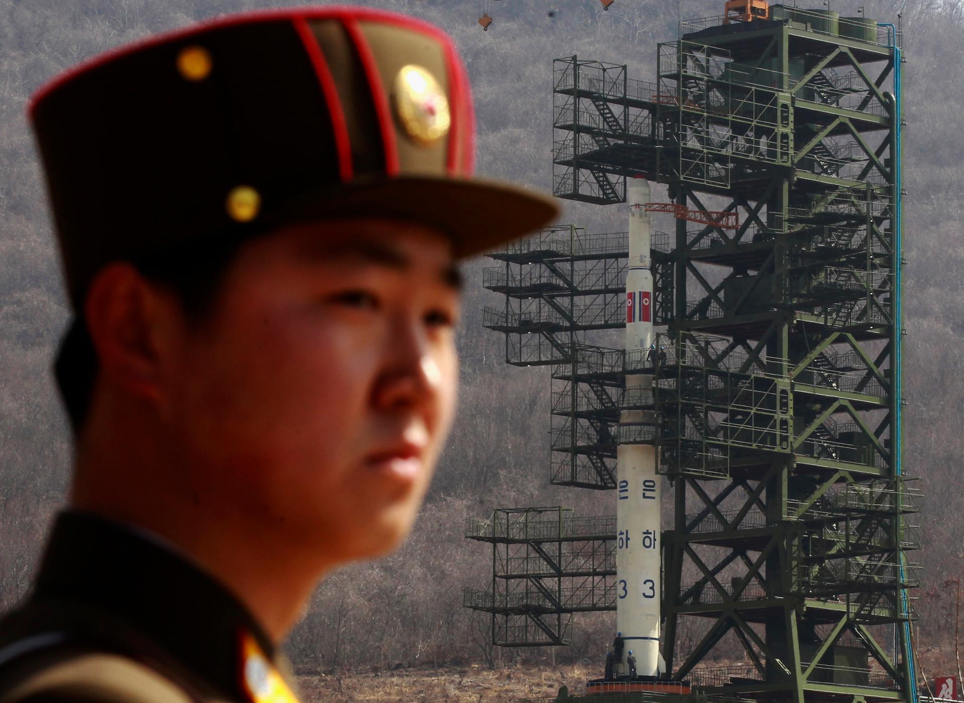 A soldier stands guard in front of the Unha-3 rocket sitting on a launch pad at the West Sea Satellite Launch Site in Pyongyang. 
